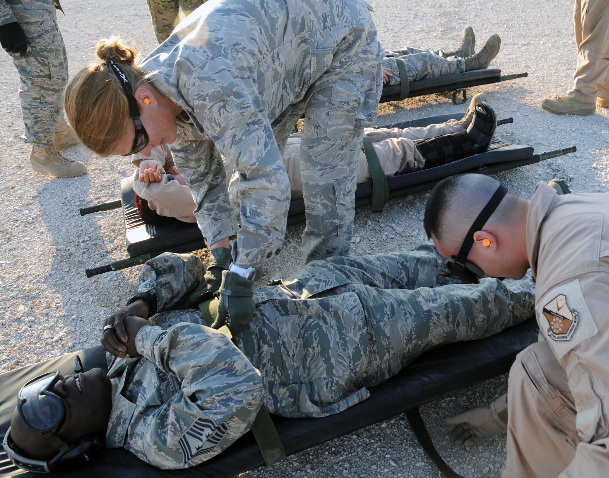 SOUTHWEST ASIA - Maj. Jennifer Prosser, Critical Care Air Transport Team nurse, and Senior Airman Vinny Babauta, CCATT Respiratory Technician, straps Chief Master Sgt. Rory Wicks, 379th Air Expeditionary Wing command chief, to a litter during a mock 379th Expeditionary Aeromedical Evacuation Squadron engines running on-load mission Dec. 4. (U.S. Air Force photo/Capt. Angela Webb)