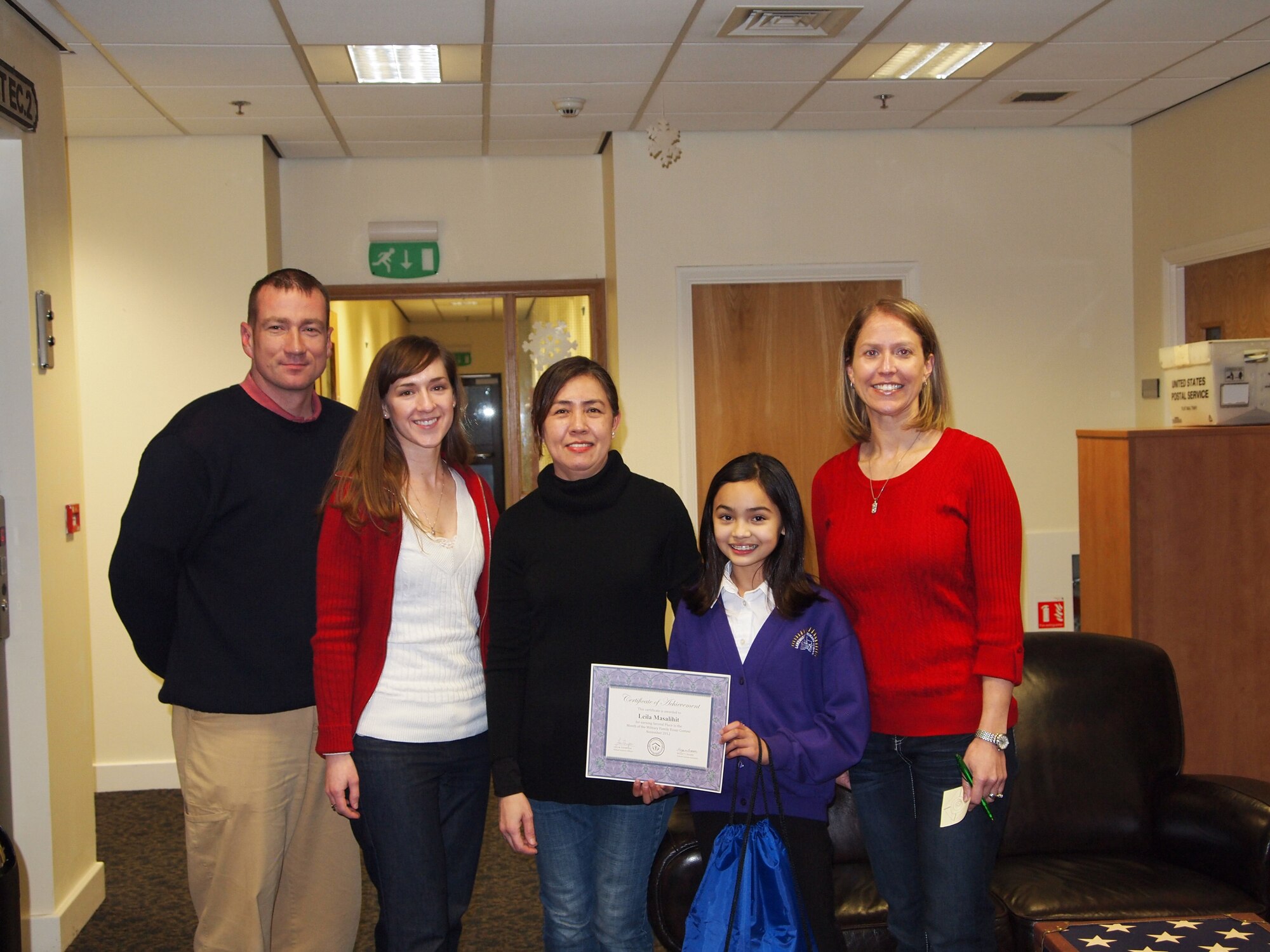 LAKENHEATH, England - Lakenheath Primary School year five essay contest winner poses for a photo with Anthony Duggan (left), 48th Mission Support Group deputy director, and members of the RAF Lakenheath/Mildenhall School Liaison Office. (Courtesy Photo)