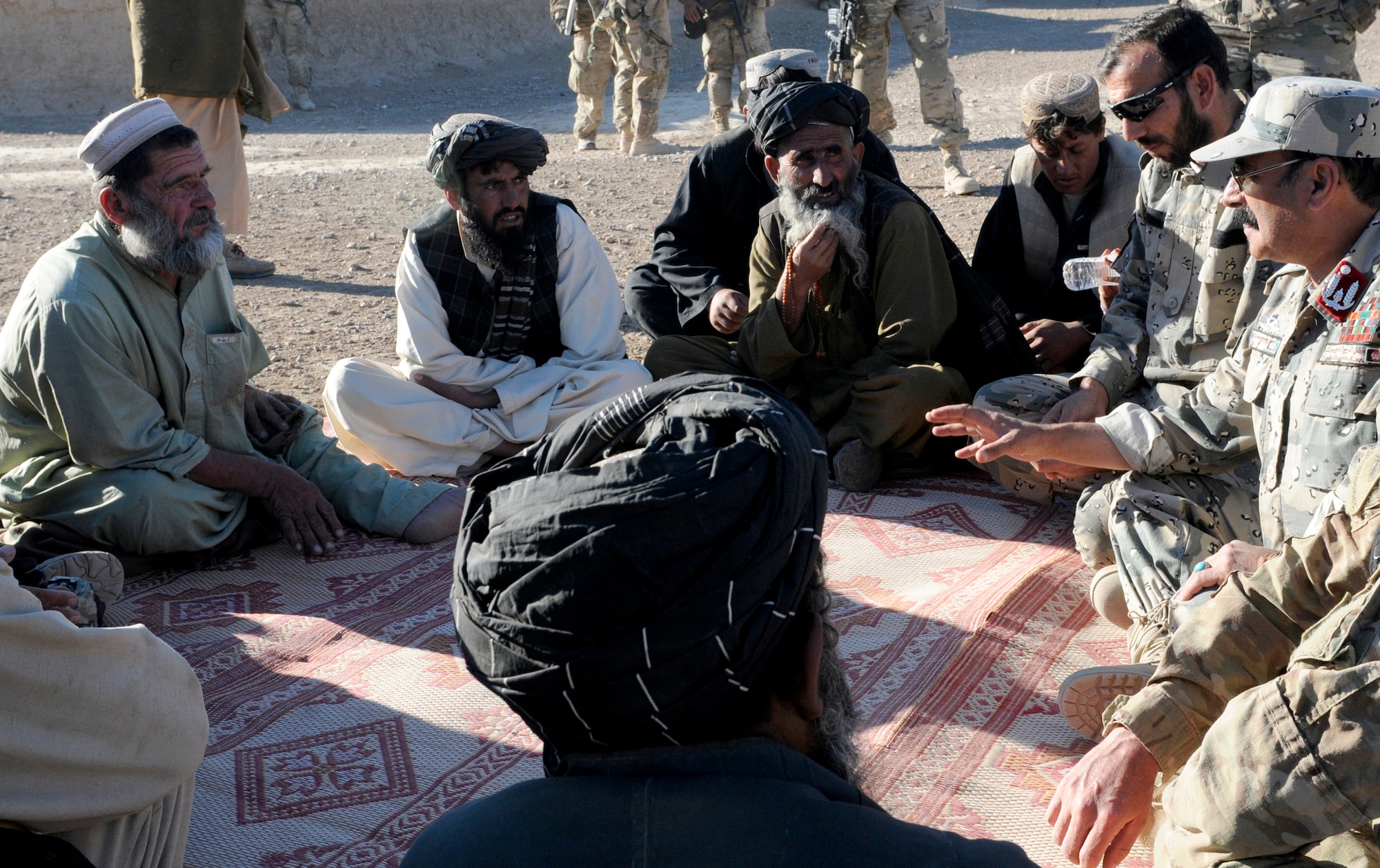 Maj. Asmatulla Safi (upper right), an operations officer with 3rd Zone Afghan Border Police and Col. Fasil Karim Karimi (on right with hat), chief of staff for 3rd Zone Afghan Border Police, speak with villagers of Gagre Naw, Afghanistan, during Operation Southern Strike IV, Nov. 18, 2012. (U.S. Army Photo/Staff Sgt. Ryan Sheldon)