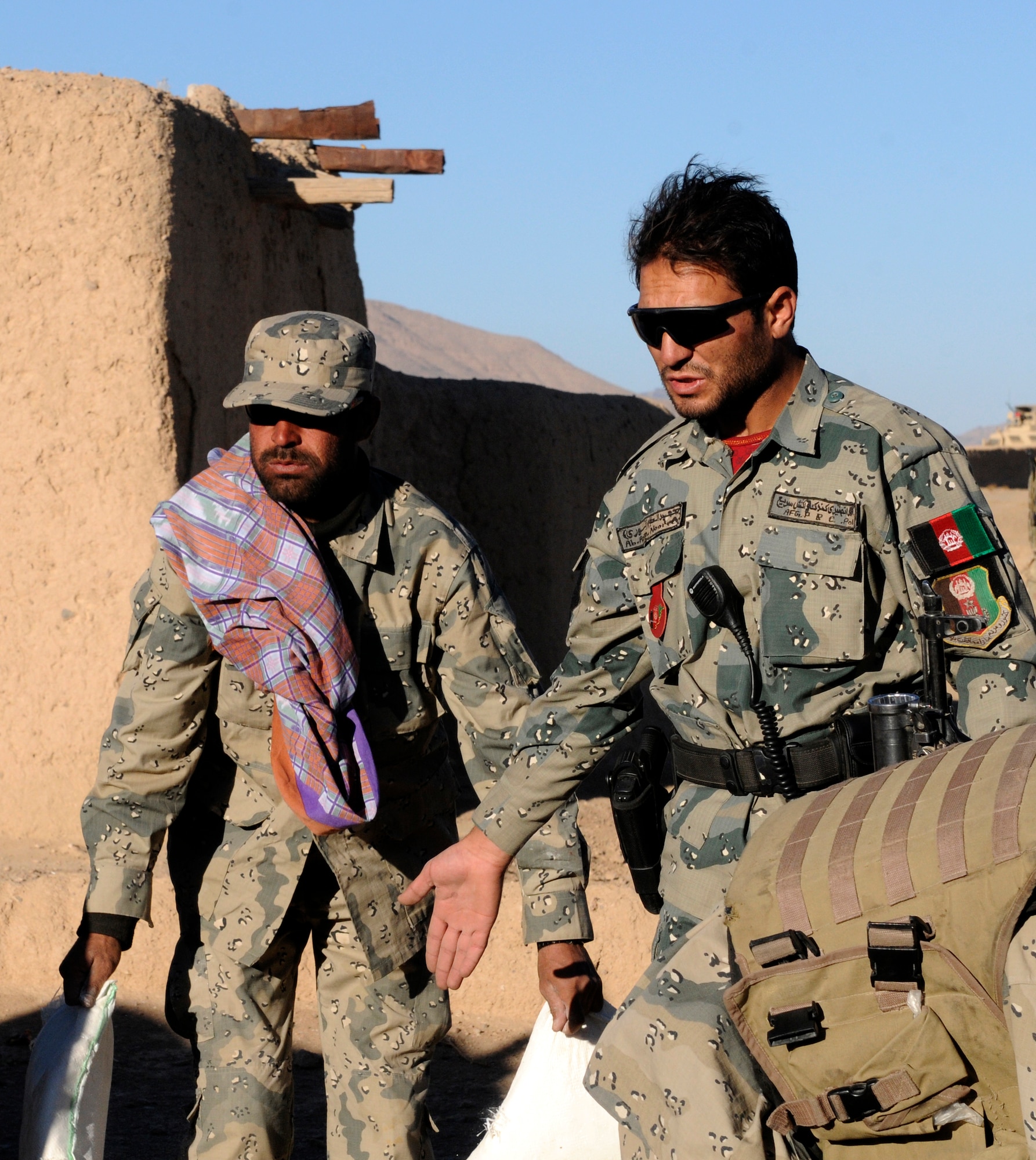 Lt. Abdul Azim Nooree (right), an officer with the Afghan Border Police, assists handing out humanitarian aid in the village of Gagre Naw, Afghanistan, during Operation Southern Strike IV, Nov. 18, 2012. (U.S. Army Photo/Staff Sgt. Ryan Sheldon)