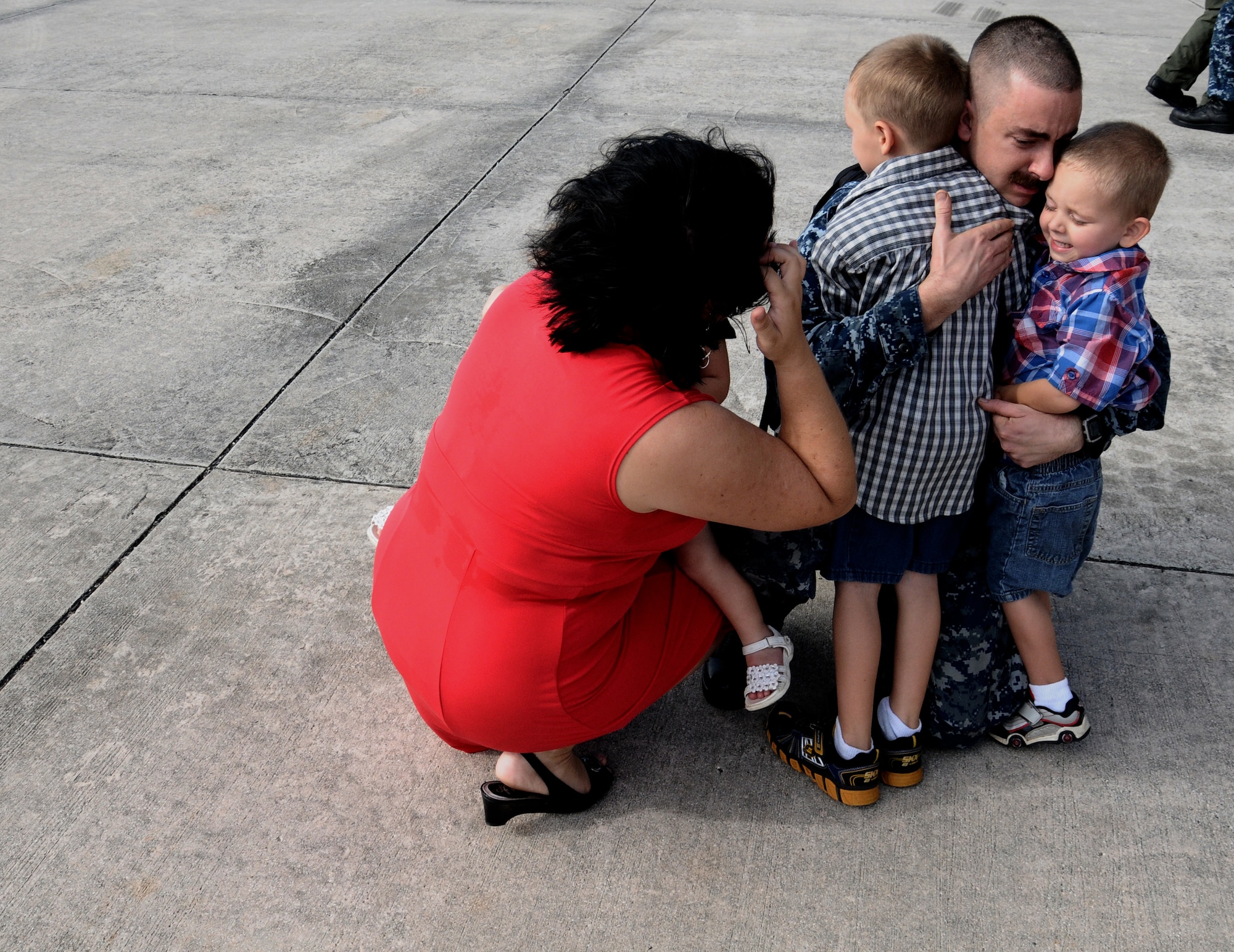 Aviation structural mechanic Chief Petty Officer Joshua Peters, from Helicopter Sea Combat Squadron TWO FIVE, embraces his family upon returning from the USNS Amelia Earhart on Andersen Air Force Base, Guam, Dec. 13,2012. The sailors were aboard the USNS Amelia Earhart (T-AKE 6) for deployments ranging from 3 to 10 months. Detachment ONE conducted vertical replenishment operations in support of Task Force 73 (CTF-73) while offering logistics and search and rescue support.   (U.S. Air Force photo by Airman 1st Class Mariah Haddenham / Released)