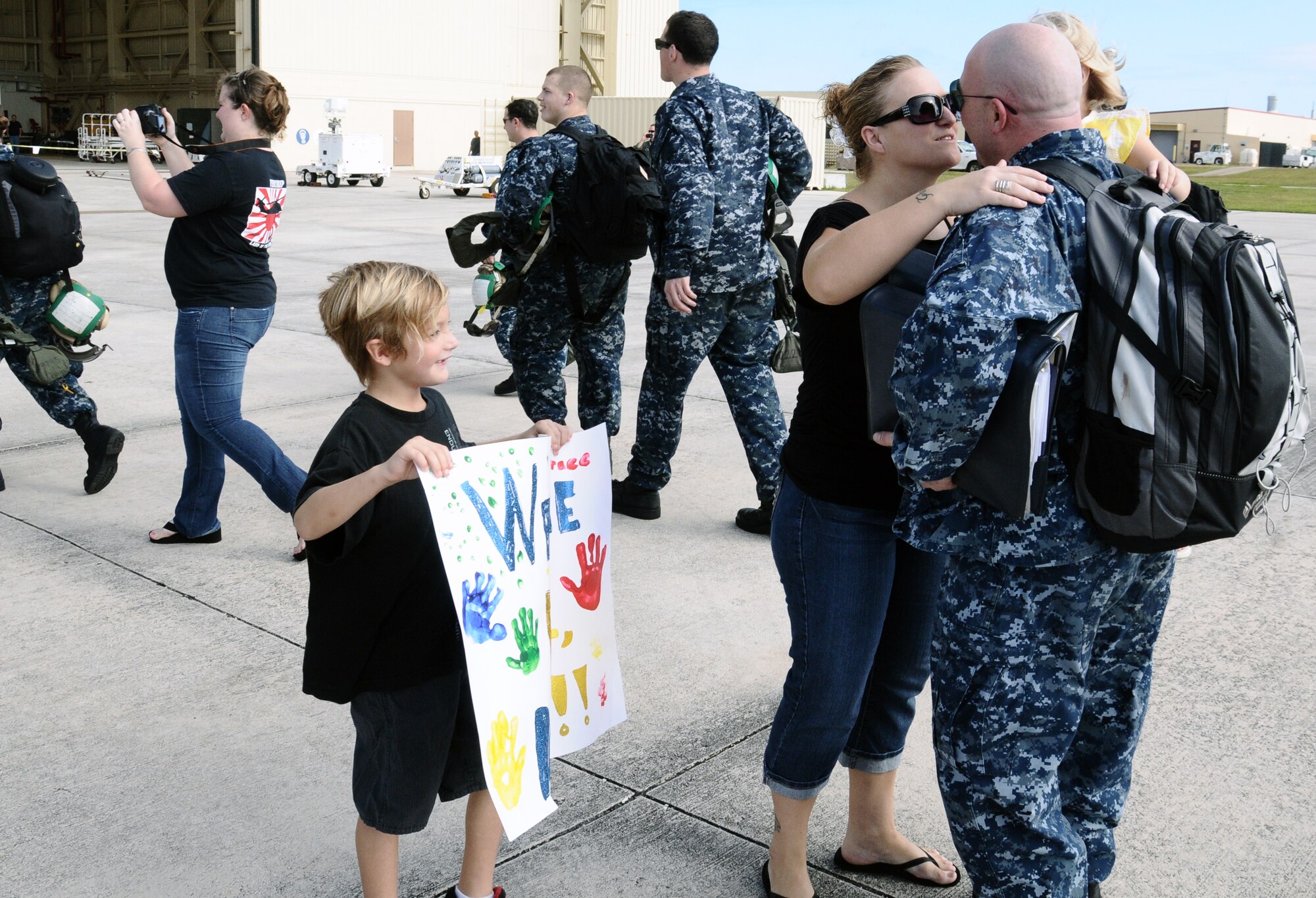 Aviation structural mechanic Chief Petty Officer Chad Burg, Helicopter Sea Combat Squadron TWO FIVE, embraces his wife upon his return from the USNS Amelia Earhart at Andersen Air Force Base, Guam, Dec. 13,2012. While aboard the Earhart, the detachment moved 3 million pounds of ordnance and cargo, supporting 37 missions and totaling 322 flight hours. Detachment ONE conducted vertical replenishment operations in support of Commander, Task Force 73 while offering logistics and search and rescue support. (U.S. Air Force photo by Airman 1st Class Mariah Haddenham / Released)