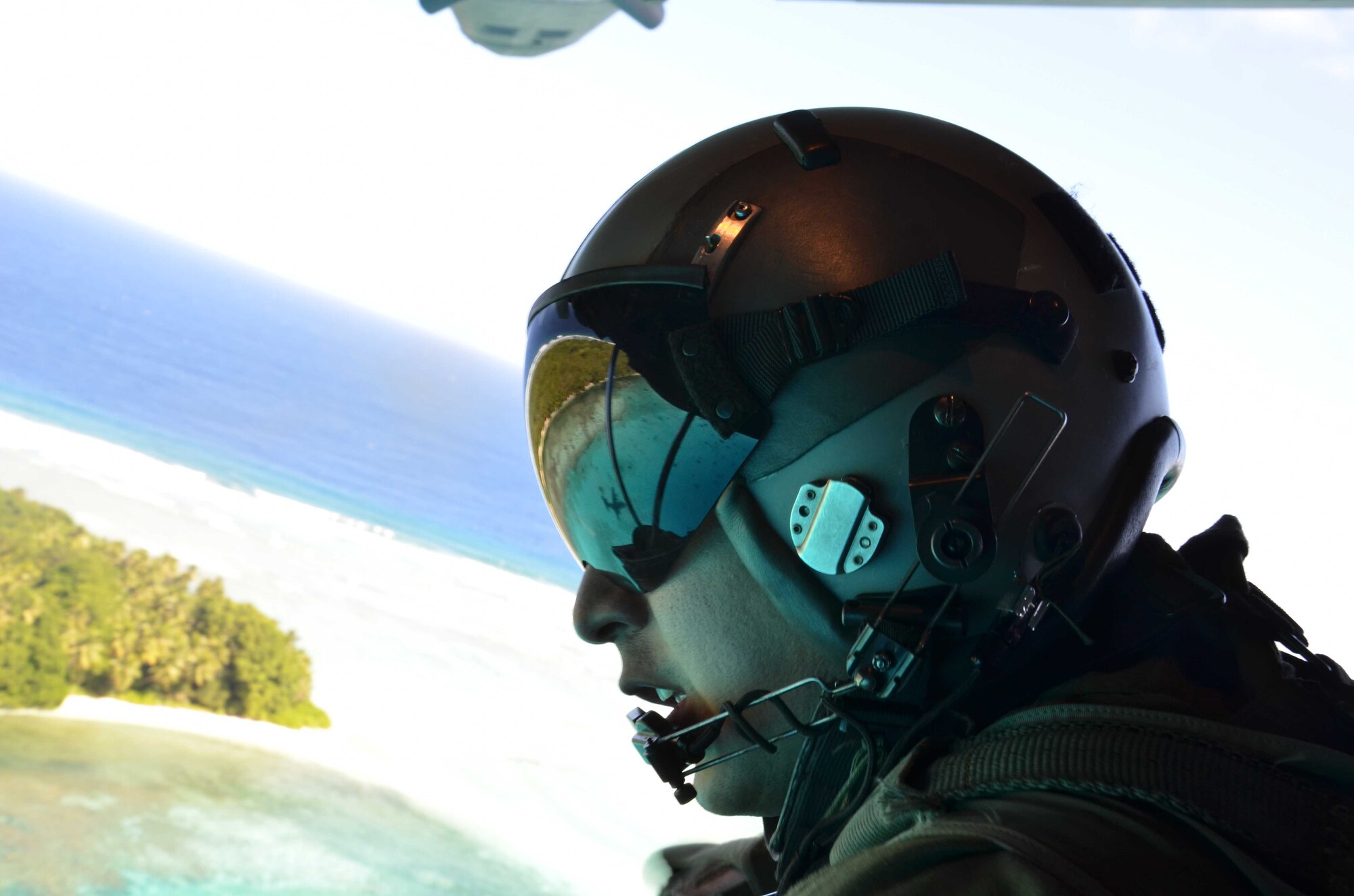 Staff Sgt. Nick Alarcon, 36th Airlift Squadron instructor loadmaster, looks out the back of a U.S. Air Force C-130 Hercules after dropping a box of humanitarian assistance goods during an Operation Christmas Drop flight from Andersen Air Force Base, Guam, Dec. 14, 2012. Each year OCD provides aid to more than 30,000 islanders in Chuuk, Palau, Yap, Marshall Islands and Commonwealth of the Northern Mariana Islands. This year is the 61st anniversary of OCD, making it the longest running humanitarian mission in the world. In total, there are eight planned days of air drops, with 54 islands scheduled to receive humanitarian aid. (U.S. Air Force photo/Staff Sgt. Alexandre Montes/Released)