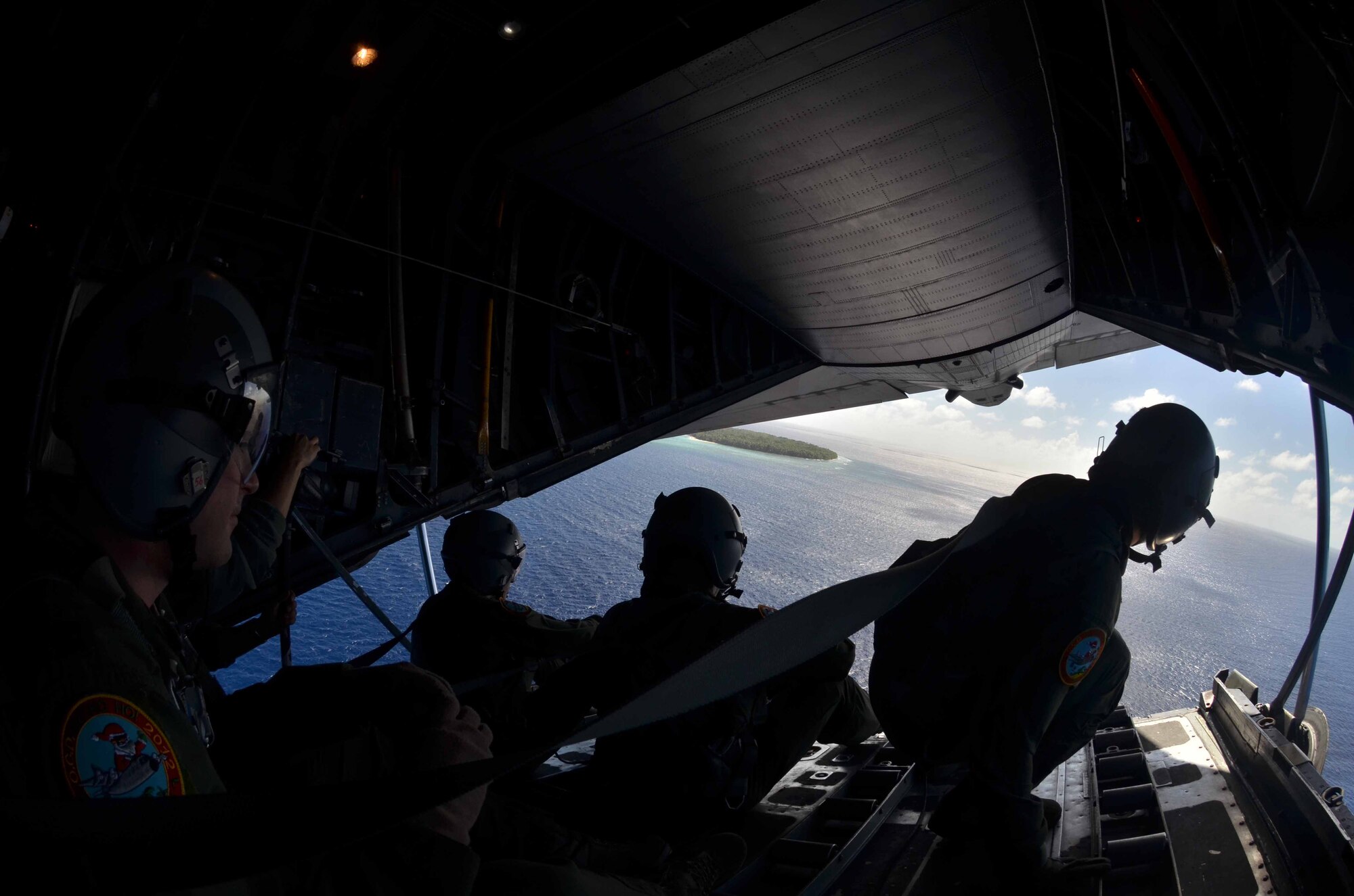 Loadmasters from the 36th Airlift Squadron look out the back of a U.S. Air Force C-130 Hercules after dropping a box of humanitarian assistance goods during a Operation Christmas Drop flight from Andersen Air Force Base, Guam, Dec. 14, 2012. Each year OCD provides aid to more than 30,000 islanders in Chuuk, Palau, Yap, Marshall Islands and Commonwealth of the Northern Mariana Islands. This year is the 61st anniversary of OCD, making it the longest running humanitarian mission in the world. In total, there are eight planned days of air drops, with 54 islands scheduled to receive humanitarian aid. (U.S. Air Force photo/Staff Sgt. Alexandre Montes/Released) 