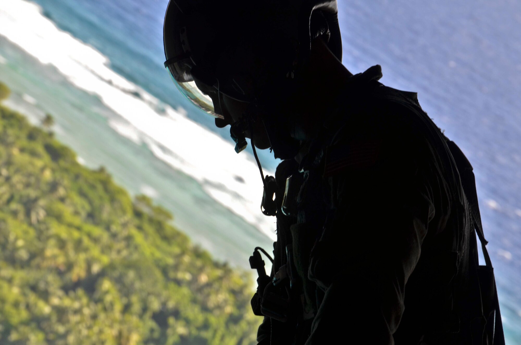 Senior Airman Timothy Oberman, 36th Airlift Squadron loadmaster, looks over an island after helping push a box of humanitarian assistance goods out of a U.S. Air Force C-130 Hercules during an Operation Christmas Drop flight from Andersen Air Force Base, Guam, Dec. 14, 2012. Each year OCD provides aid to more than 30,000 islanders in Chuuk, Palau, Yap, Marshall Islands and Commonwealth of the Northern Mariana Islands. This year is the 61st anniversary of OCD, making it the longest running humanitarian mission in the world. In total, there are eight planned days of air drops, with 54 islands scheduled to receive humanitarian aid. (U.S. Air Force photo/Staff Sgt. Alexandre Montes/Released)