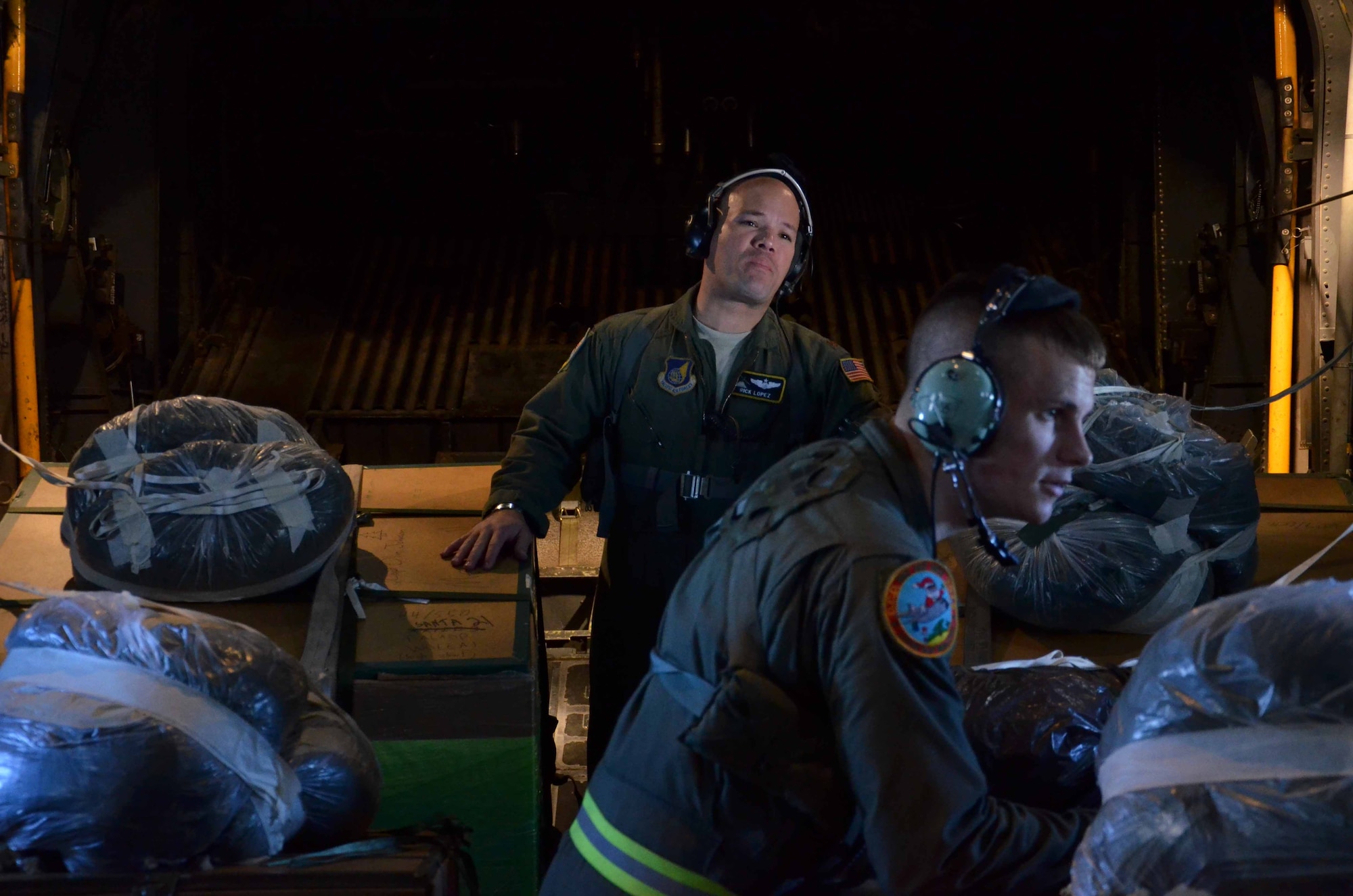 Maj. Ricardo Lopez, 374th Airlift Wing, watches as Senior Airman Timothy Oberman, 36th Airlift Squadron loadmaster, inspects each pallet during their Operation Christmas Drop delivery from Andersen Air Force Base, Guam, Dec. 14, 2012. Each year OCD provides aid to more than 30,000 islanders in Chuuk, Palau, Yap, Marshall Islands and Commonwealth of the Northern Mariana Islands. This year is the 61st anniversary of OCD, making it the longest running humanitarian mission in the world. In total, there are eight planned days of air drops, with 54 islands scheduled to receive humanitarian aid. (U.S. Air Force photo/Staff Sgt. Alexandre Montes/Released)