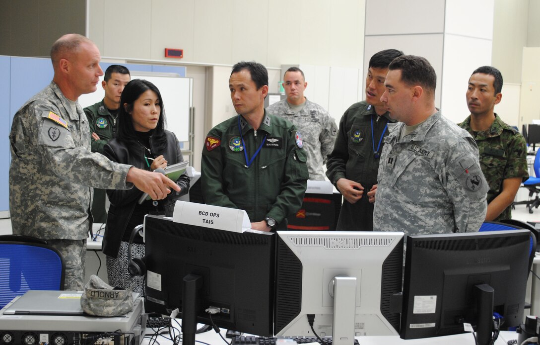 Col. Stephen Myers, 5th Battlefield Coordination Detachment commander (left), discusses the coordination of bilateral air and ground operations during Yama Sakura 63 with Maj. Gen. Masashi Yamada, Air Defense Command commander (middle), in the Bilateral Air Operations Command Center at Yokota Air Base, Japan, Dec. 11, 2012. (U.S. Air Force photo by Capt. Cody Chiles)