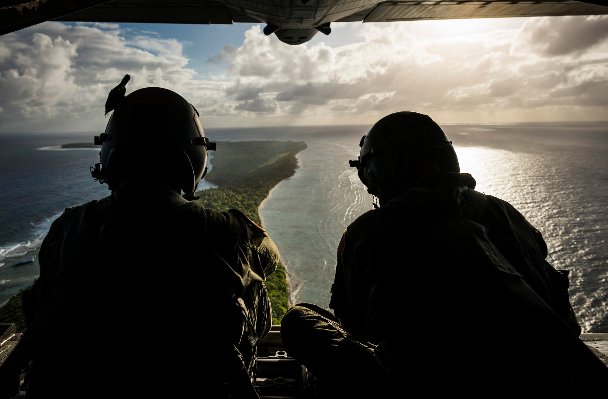 12/13/2012 - Senior Airman Timothy Oberman, left, and Staff Sgt. Nick Alarcon, loadmasters with the 36th Airlift Squadron, Yokota Air Base, Japan, watch out the back of a C-130H aircraft after dropping the first pallet of humanitarian goods to the island of Ulal Dec. 11, 2012. This year is the 61st anniversary of OCD, making it the longest running humanitarian mission in the world. (U.S. Air Force photo by Tech. Sgt. Samuel Morse/Released)
