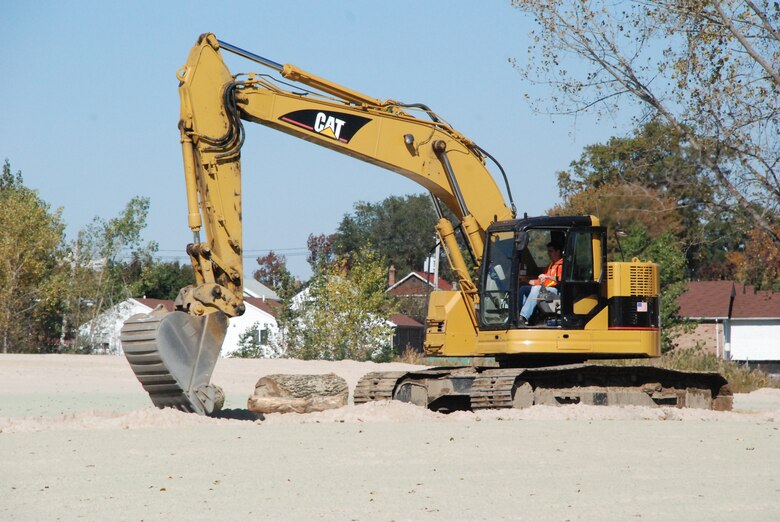 Excavator placing woody material as a feature in the recently seeded upland meadow at the Soundview Park Ecosystem Restoration Project. 