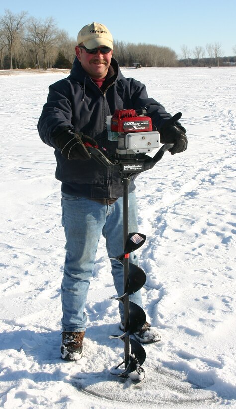 Man drilling a hole for ice fishing.