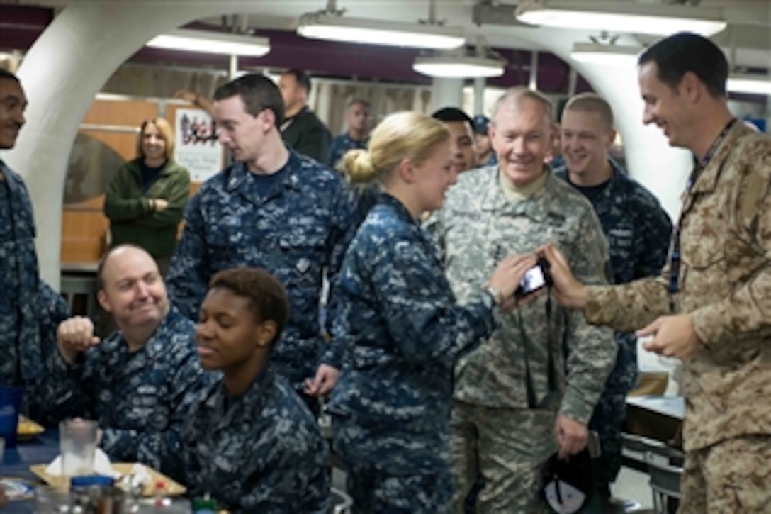 Chairman of the Joint Chiefs of Staff Gen. Martin E. Dempsey, second from right, talks with the crew of the aircraft carrier USS John C. Stennis (CVN 74) as the ship operates in the Persian Gulf on Dec. 13, 2012.   Athletes and entertainers accompanied Dempsey on the visit to the ship as part of his annual USO holiday tour.  The Stennis is deployed to the 5th Fleet area of responsibility to conduct maritime security operations and theater security cooperation efforts.  