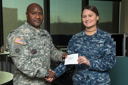 FORT GEORGE G. MEADE, Md. - U.S. Army Command Sgt. Maj. Patrick Alston, senior enlisted leader at USSTRATCOM, presents U.S. Navy Petty Officer 3rd Class Katymarie Barnosky with a coin and letter on behalf of the command Dec. 14. Ten USCYBERCOM enlisted personnel were recognized for their contributions to the USCYBERCOM mission of the operation and defense of DoD networks.
