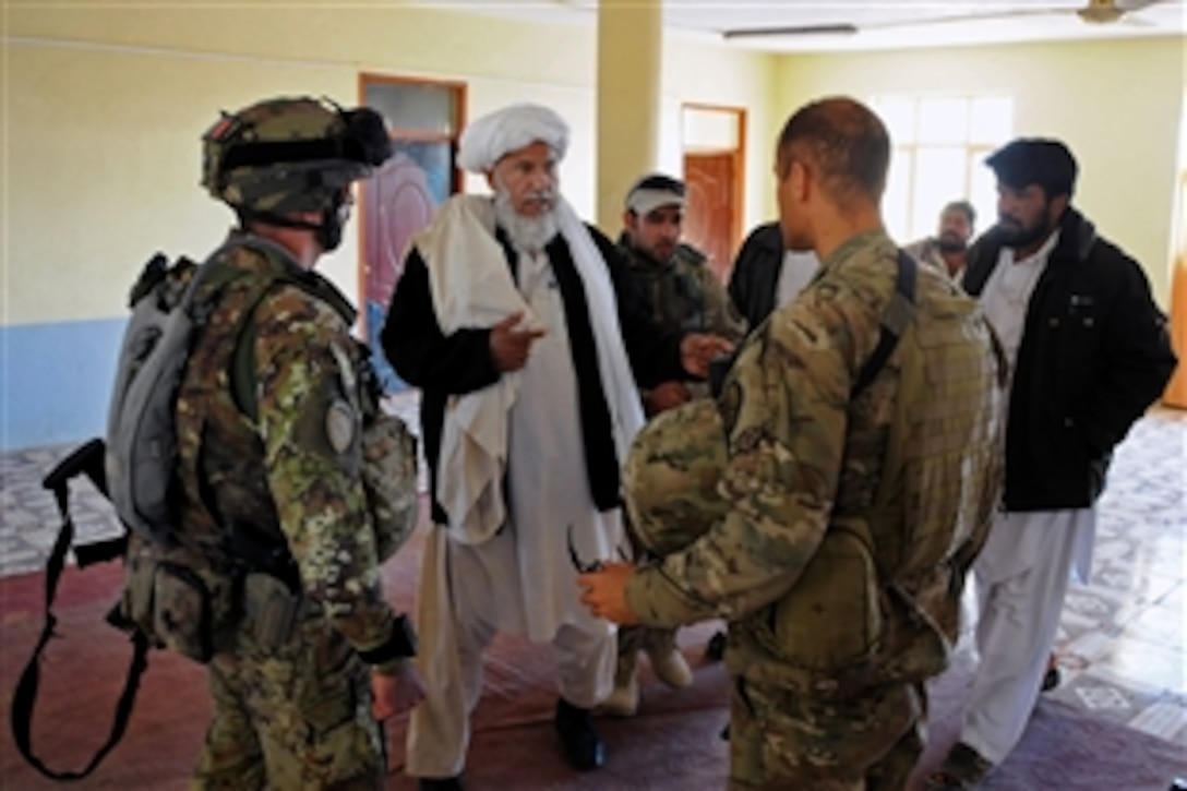 U.S. Navy Cmdr. Louis McCray, right, and Italian Capt. Mario D'Angelo, left, talk with Bala Boluk District Gov. Sayed Mohammed, center, at the conclusion of their key leader engagement at the Bala Boluk district center in Afghanistan’s Farah province, Dec. 9, 2012. McCray is commanding officer of Provincial Reconstruction Team Farah.