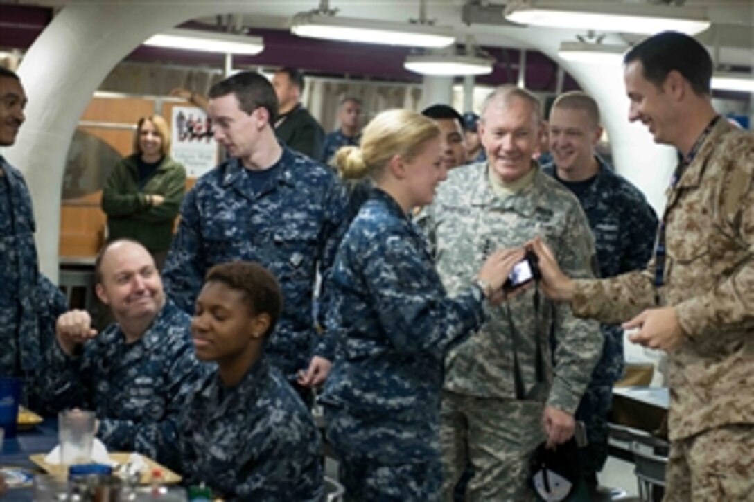 Chairman of the Joint Chiefs of Staff Gen. Martin E. Dempsey, second from right, talks with the crew of the aircraft carrier USS John C. Stennis (CVN 74) as the ship operates in the Persian Gulf on Dec. 13, 2012.   Athletes and entertainers accompanied Dempsey on the visit to the ship as part of his annual USO holiday tour.  The Stennis is deployed to the 5th Fleet area of responsibility to conduct maritime security operations and theater security cooperation efforts.  