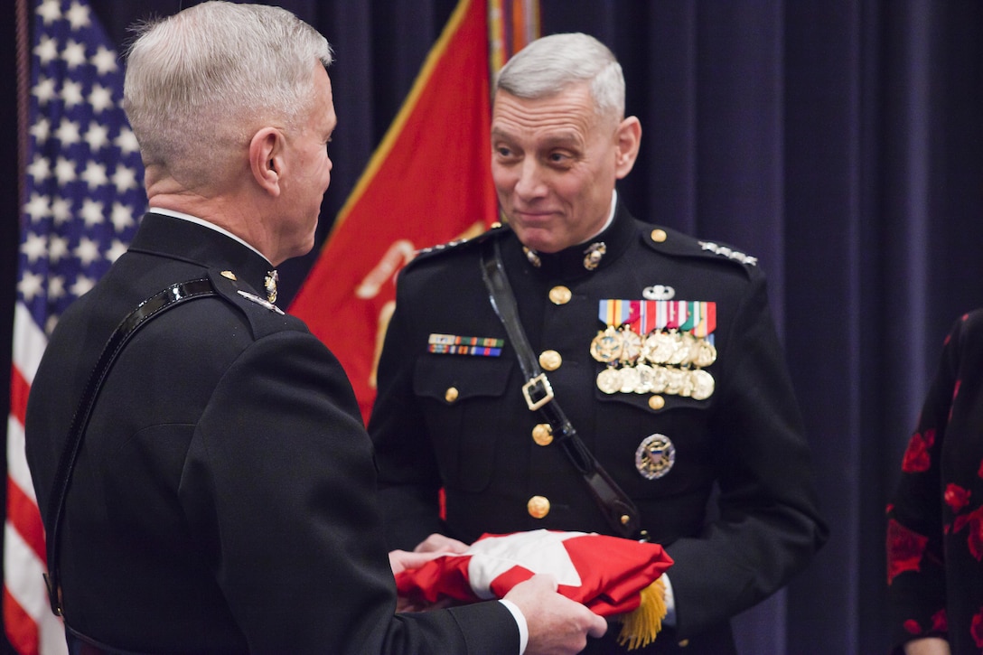 Gen. James F. Amos, commandant of the Marine Corps, left, presents a four-star general flag to Gen. John M. Paxton, Jr., assistant commandant of the Marine Corps, right, during a promotion and appointment ceremony at Marine Barracks Washington, D.C., Dec. 15. Paxton relieves Gen. Joseph F. Dunford, former assistant commandant, of the post. Paxton was promoted to his current rank of general and sworn in to his new position by Amos in the same event. In attendance to the ceremony were a number of former commandants, assistant commandants and sergeants major of the Marine Corps as well as Paxton's family, friends, former and current staff members, and foreign dignitaries.