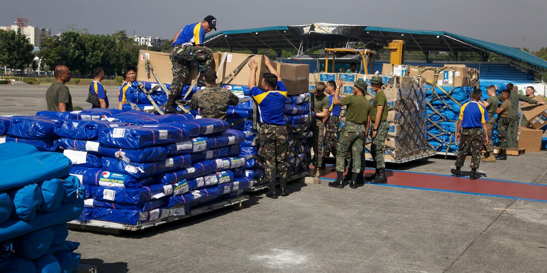 Philippine service members and U.S. Marines organize relief supplies Dec. 13 at Villamor Air Base in Manila, Republic of the Philippines. After the supplies were organized onto pallets, they were flown to Davao International Airport in Mindanao to be distributed to the victims of Typhoon Pablo (international name Bopha) by Philippine Government and nongovernmental organizations. 