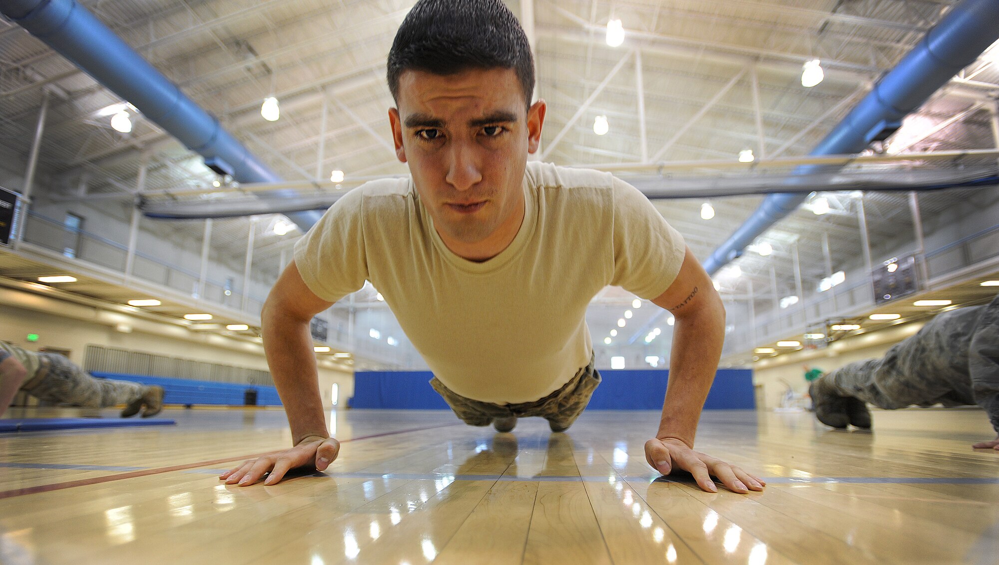 MINOT AIR FORCE BASE, N.D. -- Senior Airman Adam Gonzalez, 5th Aircraft Maintenance Squadron weapons load crew member, competes in the 5th Bomb Wing Annual Awards Banquet Push-Up Contest Fundraiser Dec. 14. The unit with the highest total push-up count recieved a memorabilia plaque and two packs of Red-Bull and the first place winners recieved a $25 gift card, with other prizes for second and third place winners. (U.S. Air Force photo/Senior Airman Jose L. Hernandez)