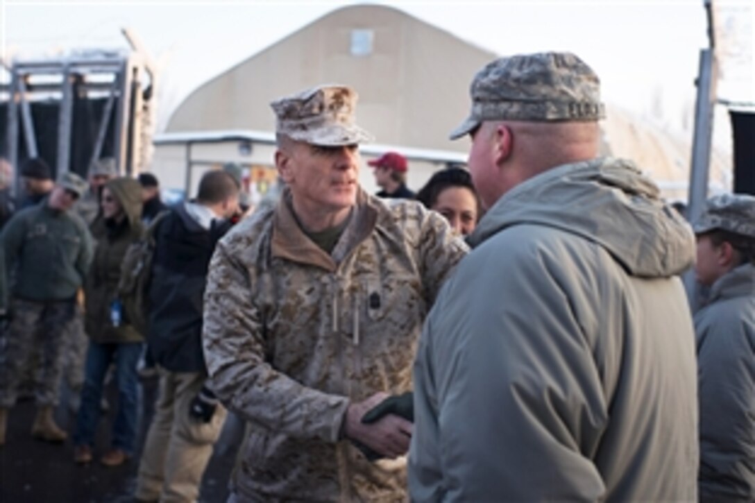U.S. Marine Corps Sgt. Maj. Bryan Battaglia, senior enlisted advisor to the chairman of the Joint Chiefs of Staff, shakes hands with a U.S. airman based at the transit center in Manas, Kyrgyzstan, Dec. 14, 2012. Battaglia visited the center as part of the USO Holiday Tour.