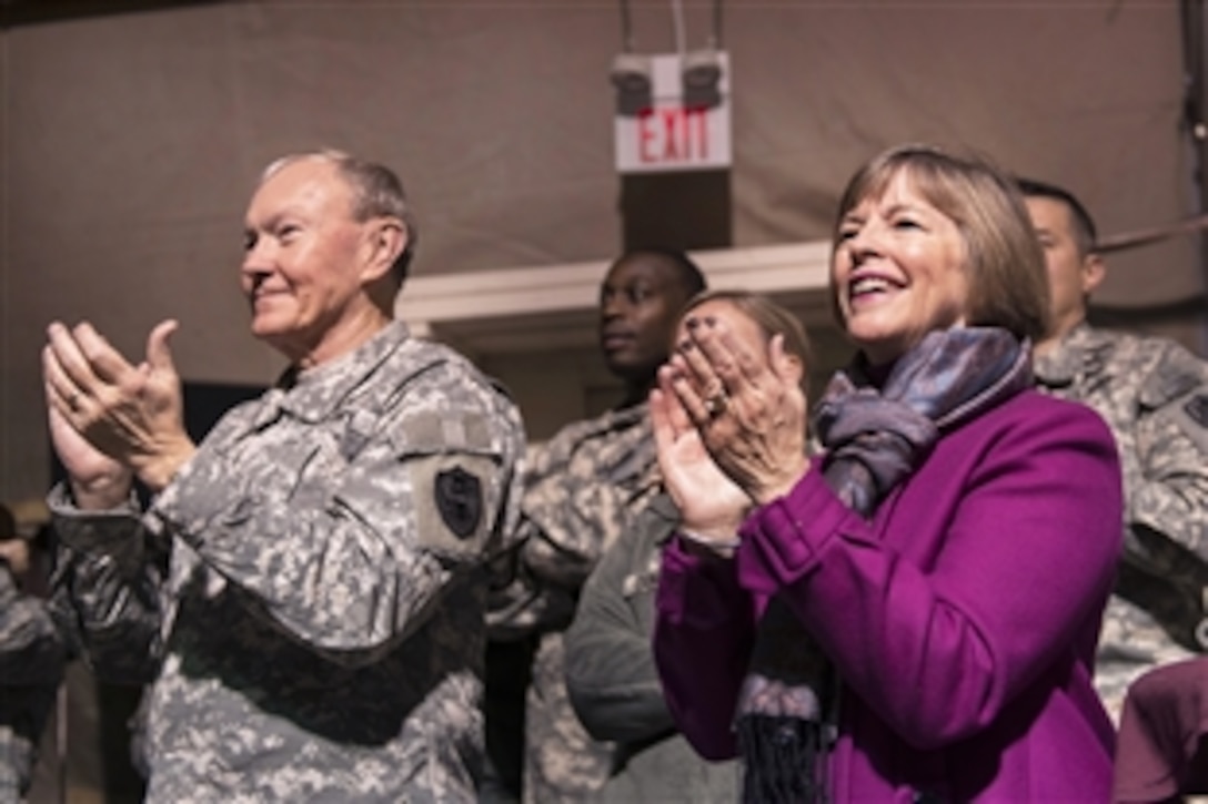 U.S. Army Gen. Martin E. Dempsey, chairman of the Joint Chiefs of Staff, and his wife, Deanie, applaud during a USO-sponsored holiday tour at the transit center in Manas, Kyrgyzstan, Dec. 14, 2012. 