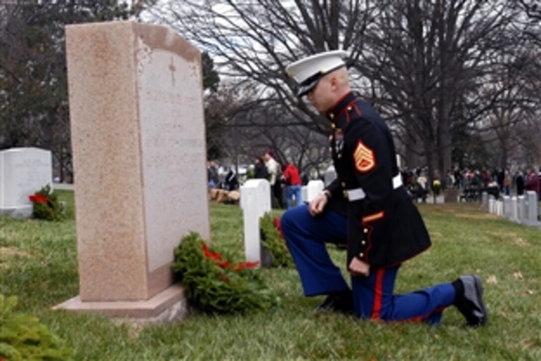 Marine Corps Staff Sgt. Micheal A. Cornelio pays respect after placing a wreath at a grave marker during Wreaths Across America at Arlington National Cemetery in Arlington, Va., Dec. 15, 2012. Cornelio is assigned to Marine Cryptologic Support Battalion on Fort Meade, Md.