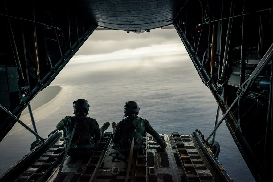 OVER THE PACIFIC OCEAN -- Capt. Ryan Turonek, left, and Senior Airman Timothy Oberman, 36th Airlift Squadron, sit on the back ramp of a C-130 Hercules after a successful low-cost, low altitude drop during Operation Christmas Drop Dec. 13, 2012. While used as a training opportunity for C-130 crews, each crew member expressed how gratifying it was to make a difference in the lives of the Pacific islanders they dropped humanitarian aid to. (U.S. Air Force photo by Tech. Sgt. Samuel Morse)