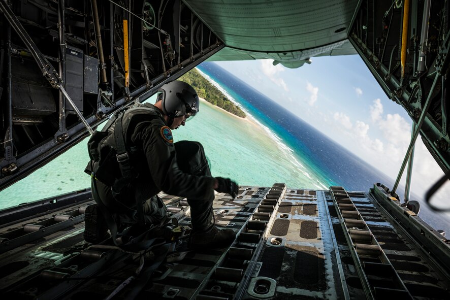 OVER THE PACIFIC OCEAN -- Senior Airman Timothy Oberman, 36th Airlift Squadron loadmaster, secures tie-down straps after a successful low-cost, low-altitude drop during Operation Christmas Drop, Dec. 13, 2012. All of the supplies used to create the bundles of humanitarian aid are donated each year, including the rigging and parachutes. (U.S. Air Force photo by Tech. Sgt. Samuel Morse)