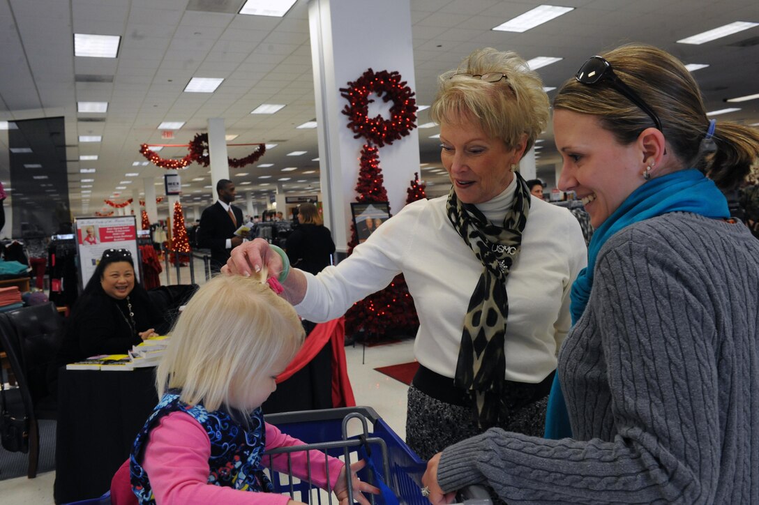 Bonnie Amos, wife of the Commandant of the Marine Corps Gen. James F. Amos, adjusts the hair bow of Trinity, 2, while meeting her mother Lauren Lee, during the book signing for the “First Lady of the Marine Corps Recommended Reading List,” at the Marine Corps Main Exchange on Friday. Bonnie spoke with the spouses about the books on the list and what some of the struggles military wives deal with. (U.S. Marine Corps photo by Lance Cpl. Tabitha Bartley/released)