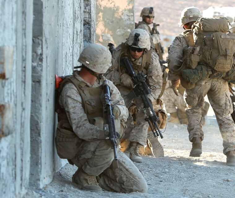 Marines with Co. E, 2nd Battalion, 4th Marine Regiment, run along the wall of a building during their assault on Range 210 Dec. 11, 2012 during Steel Knight 13.
