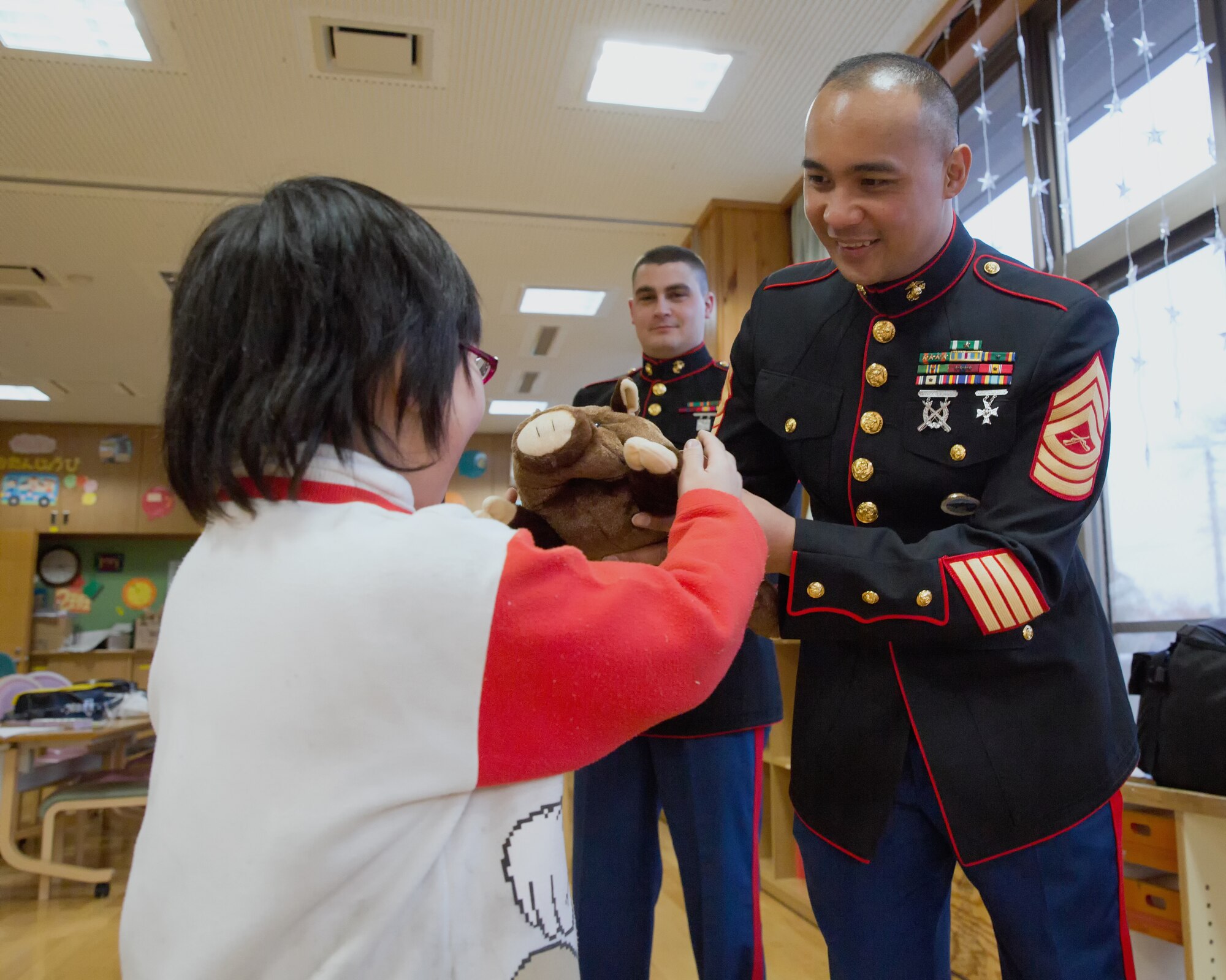 AKIRUNO CITY, Japan -- U.S. Marine Corps Master Sgt. Arsenio Cortez, U.S. Forces Japan, present child a toy as Christmas gift at Ajiro orphanage in Akiruno city, Tokyo, Dec. 14, 2012 during annual USMC Reserve Toys for Tots drive. Toys for Tots began in 1947, when Maj. Bill Hendricks and a group of Marine Reservists in Los Angeles collected and distributed 5,000 toys to needy children. (U.S. Air Force photo by Osakabe Yasuo)