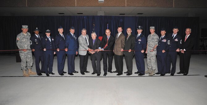 Retired Chief Master Sgt. Robert Gaylor, the fifth chief master sergeant of the Air Force (with scissors) and keynote speaker for the event, along with senior leaders, members of Richard Etchberger’s family and construction officials get ready to cut the ribbon to open the Airman Training Complex #1. (US Air Force Photo by Mr. Alan Boedeker)