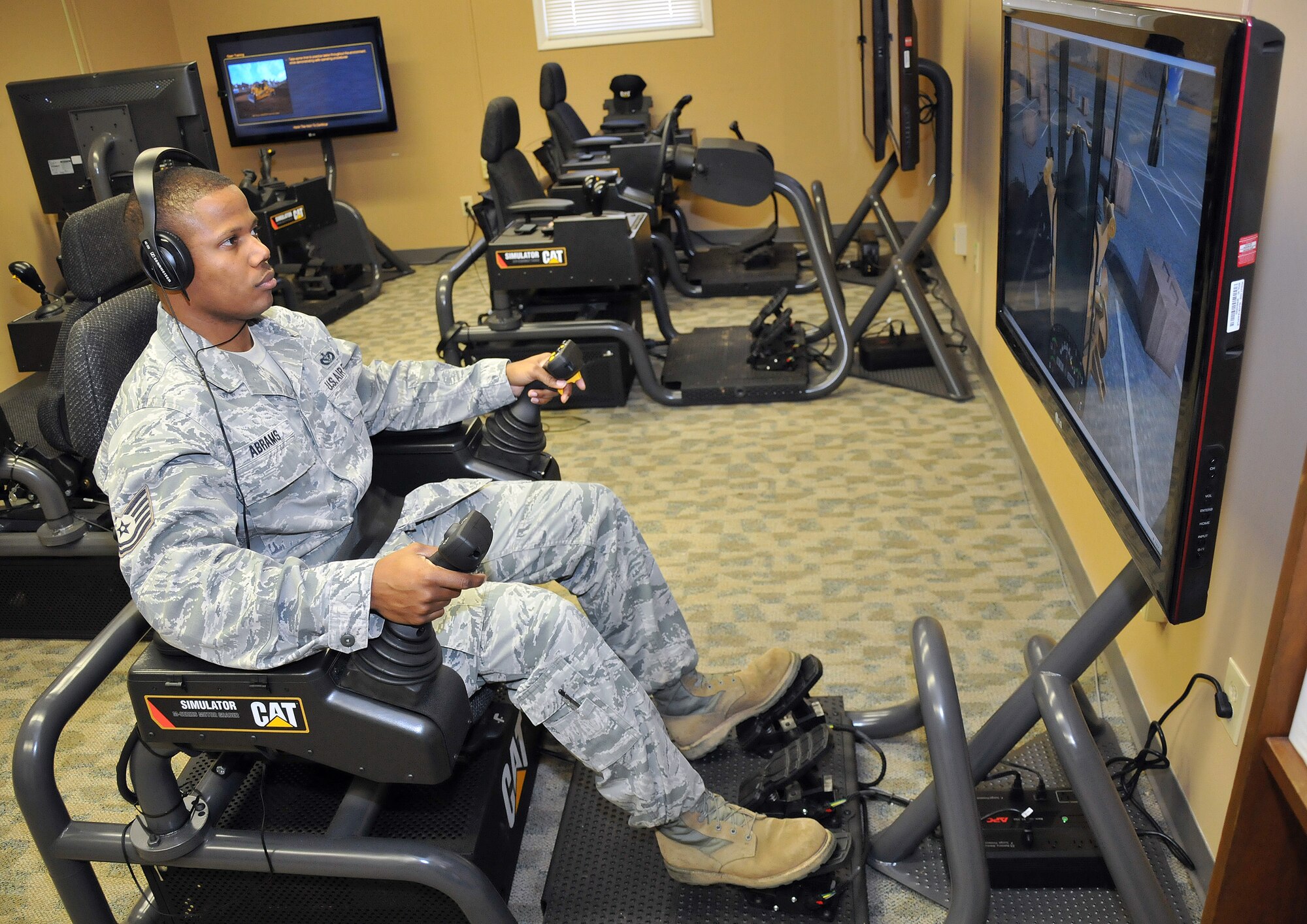 Tech. Sgt. Alexes Abrams, Air Force Reserve Command Expeditionary Combat Support Training Certification Center instructor at Dobbins Air Reserve Base, Ga., demonstrates the prototype CAT simulator soon to be in use by RED HORSE civil engineering squadrons across the Reserve command. The new trainer will provide initial qualification and upgrade training for heavy equipment operators at a significant savings to the Air Force, while providing a safer learning environment for trainees.  (U.S. Air Force photo by Senior Airman Elizabeth Van Patten)  