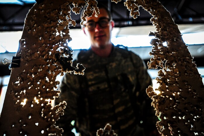 Senior Airman Joshua Buchanan, 628th Security Forces Squadron patrolman, looks at his target sheet after performing an M-4 carbine qualifying session at the Combat Arms Training and Maintenance firing range, Dec. 12, 2012, on Joint Base Charleston – Air Base, S.C.  Airmen from the 628th SFS participated in the M-4 training overseen by CATM instructors. (U.S. Air Force photo/ Senior Airman Dennis Sloan)