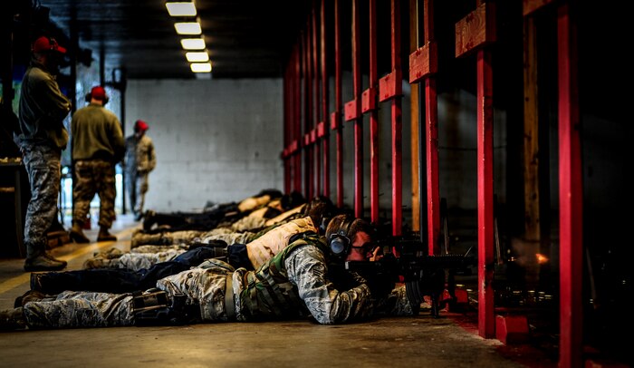 Combat Arms Training and Maintenance instructors watch Airmen from the 628th Security Forces Squadron fire M-4 carbines in the prone position during a qualifying session at the CATM firing range, Dec. 12, 2012, on Joint Base Charleston – Air Base, S.C. The qualifying course test Airmen on their ability to fire an M-4 carbine from several positions:  prone, standing and wearing a gas mask. (U.S. Air Force photo/ Senior Airman Dennis Sloan)
