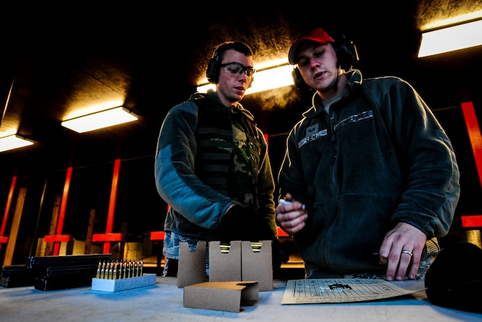 Senior Airman Joshua Lien, 628th Security Forces Squadron Combat Arms Training and Maintenance instructor, reviews a target sheet with Senior Airman Dustin Turner, 628th SFS patrolman, during an M-4 carbine qualifying session Dec. 12, 2012, at the CATM firing range on Joint Base Charleston – Air Base, S.C. Lien and several other CATM instructors oversee the weapons training while giving advice to the shooters. (U.S. Air Force photo/ Senior Airman Dennis Sloan)