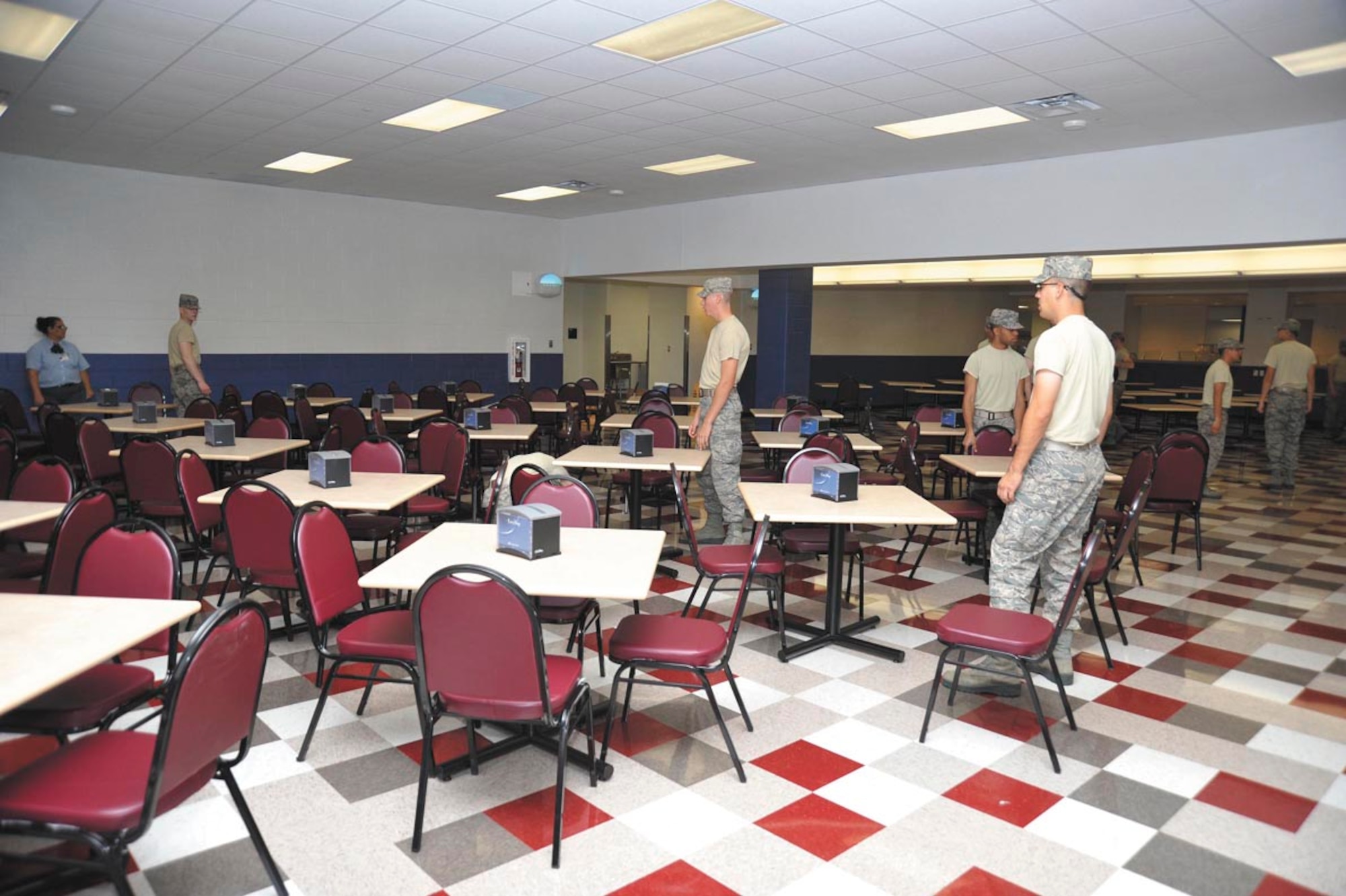 Trainees align tables and chairs in the new dining facility for Airman Dining-Classroom Facility No. 1, which opened Dec. 7.