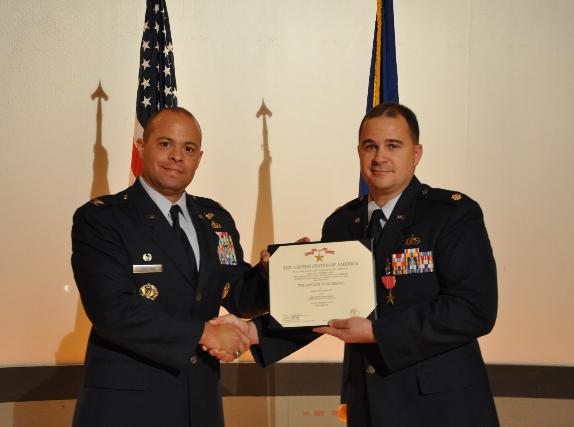 GOODFELLOW AIR FORCE BASE, Texas- Col. Mark Damiano, 17th Training Wing Commander, presents Maj. Seth Hamilton, 17th Contracting Squadron Commander, with the Bronze Star Medal certificate here, Dec. 20. Hamilton was awarded the Bronze Star Medal for his meritorious achievements while serving in Afghanistan, supporting Operation Enduring Freedom. (U.S. Air Force photo/ Airman 1st Class Erica Rodriguez)