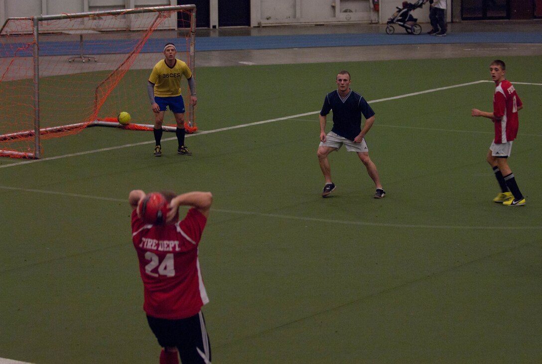Airmen of the 28th Civil Engineer Squadron defend the opponents throw-in during a soccer match in the Pride Hangar at Ellsworth Air Force Base, S.D., Dec. 11, 2012. The 28th CES has two soccer teams that squared off in one of the last games before the playoffs. The recreational soccer league is one of many intramural sports Ellsworth offers throughout the year. (U.S. Air Force photo by Airman 1st Class Audra M. Hornbacher/Released)