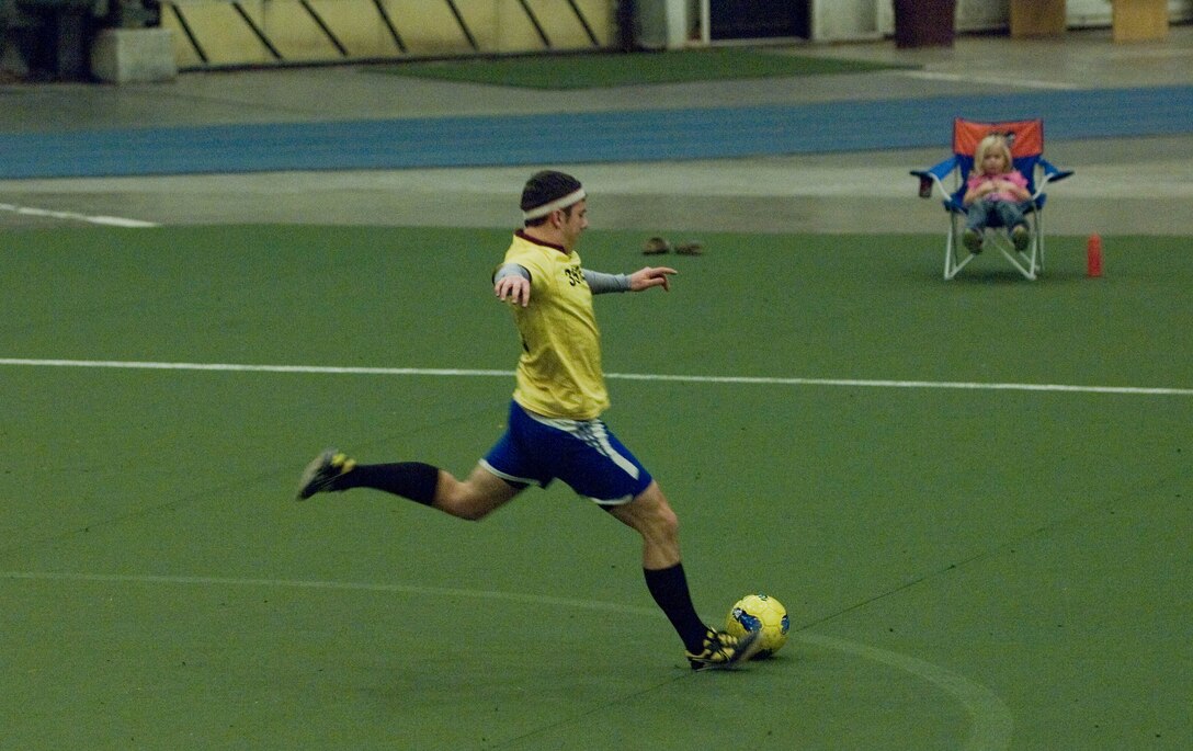 Senior Airman Scott Greco, 28th Civil Engineering Squadron explosive ordnance disposal journeyman, and goalie for CE team A, kicks the ball toward the opposing team’s goal during a soccer match in the Pride Hangar at Ellsworth Air Force Base, S.D., Dec. 11, 2012. Ellsworth’s recreational soccer league plays in the Pride Hangar every Tuesday and Thursday night, until the final four teams have earned spots in the playoffs. (U.S. Air Force photo by Airman 1st Class Audra M. Hornbacher/Released)