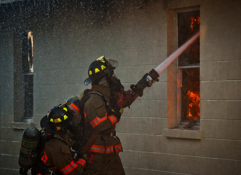 Firefighters battle a blaze through a window during a live-fire training exercise at Eglin Air Force Base, Fla., Dec. 13.  The building used for the training was scheduled to be demolished Dec. 19. (U.S. Air Force photo/Samuel King Jr.)