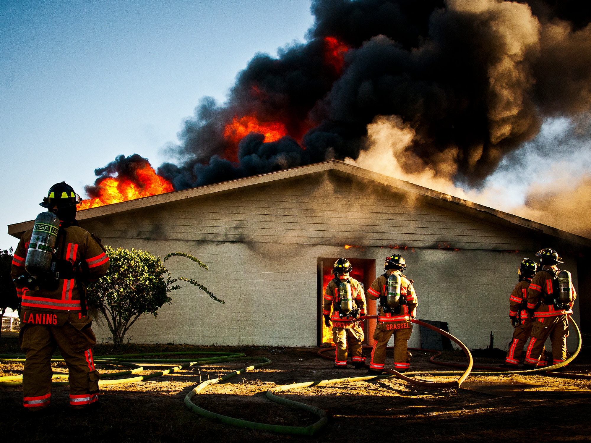Firefighters wait to begin attacking a blaze that engulfed a building during a live-fire training exercise at Eglin Air Force Base, Fla., Dec. 13.  The building used for the training was scheduled to be demolished Dec. 19. (U.S. Air Force photo/Samuel King Jr.)