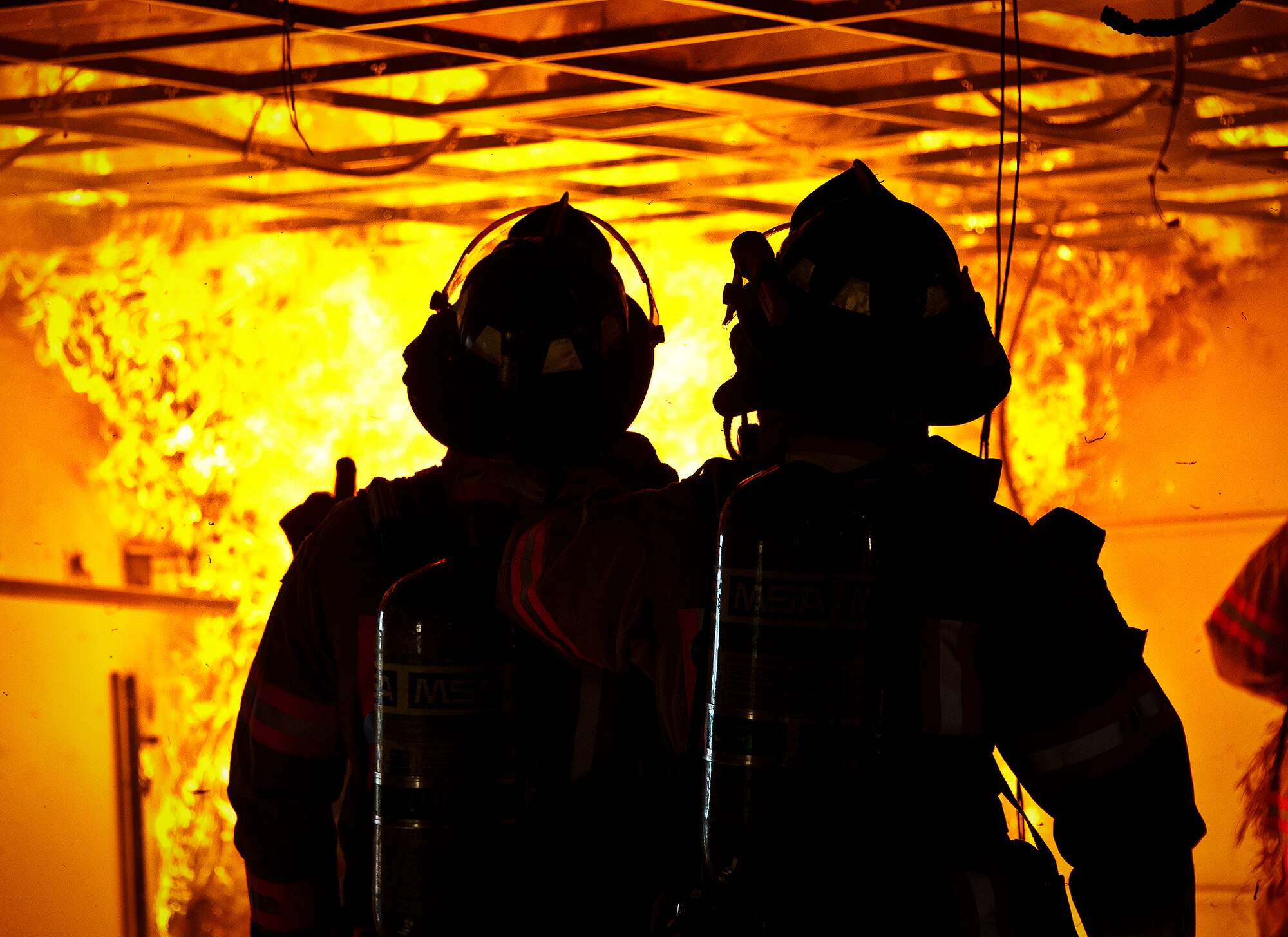 Firefighters watch as the fire spreads up to the ceiling during a structural live-fire training exercise at Eglin Air Force Base, Fla., Dec. 13.  The building used for the training was scheduled to be demolished Dec. 19. (U.S. Air Force photo/Samuel King Jr.)