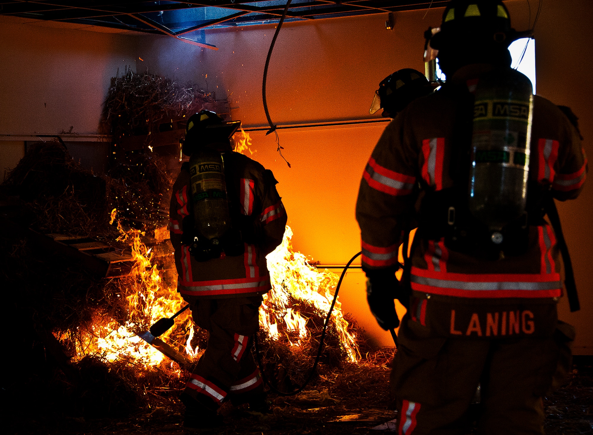 A firefighter uses a propane flame-thrower to light the fire inside a building prior to a structural live-fire training exercise at Eglin Air Force Base, Fla., Dec. 13.  The building used for the training was scheduled to be demolished Dec. 19. (U.S. Air Force photo/Samuel King Jr.)