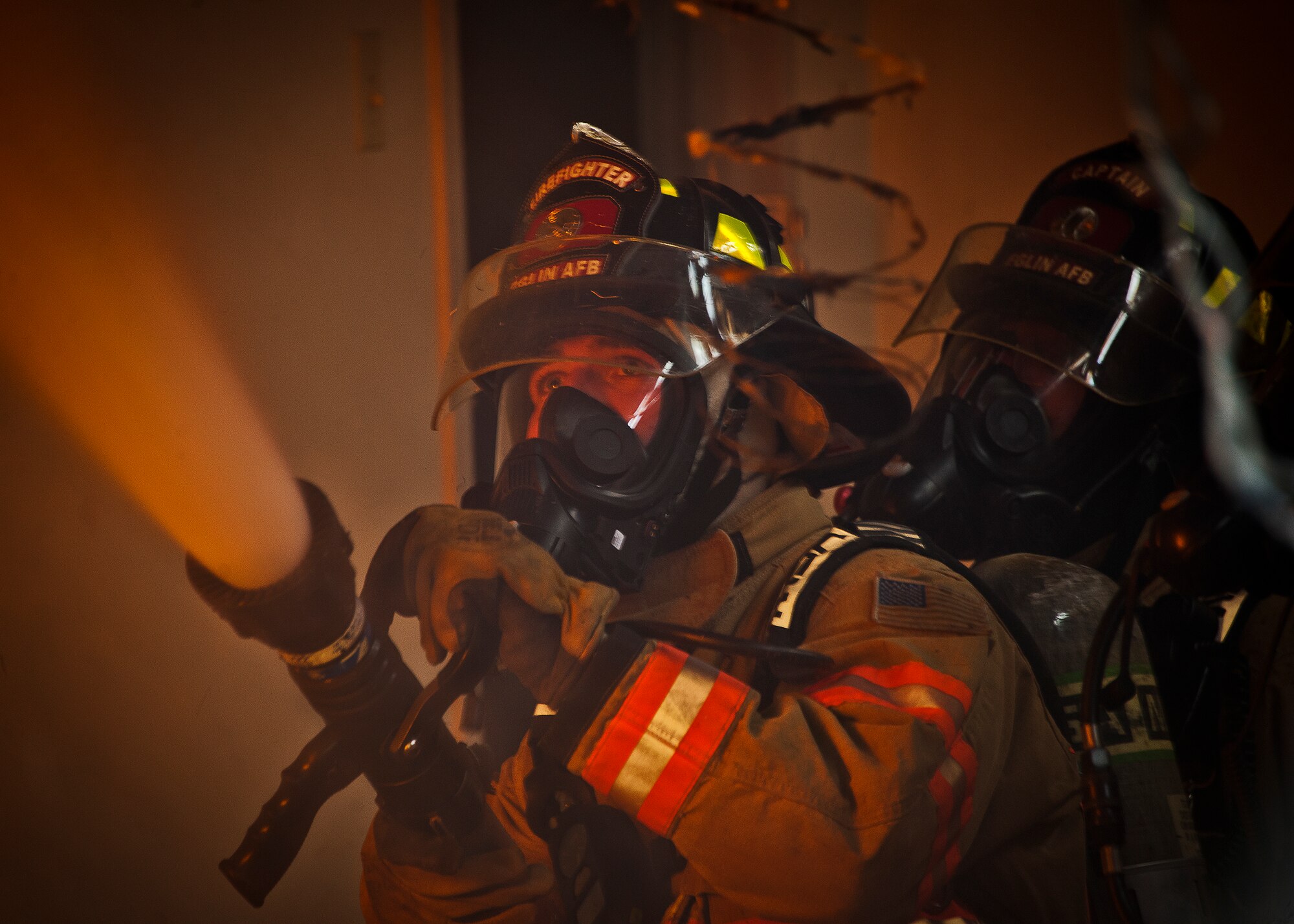 Shaun Singleton, a firefighter with the 96th Civil Engineer Squadron, sprays the blaze with the hose during a structural live-fire training exercise at Eglin Air Force Base, Fla., Dec. 13.  Two-person teams entered a building on fire and demonstrated hose and various firefighting procedures while engaging the controlled blaze.  (U.S. Air Force photo/Samuel King Jr.)
