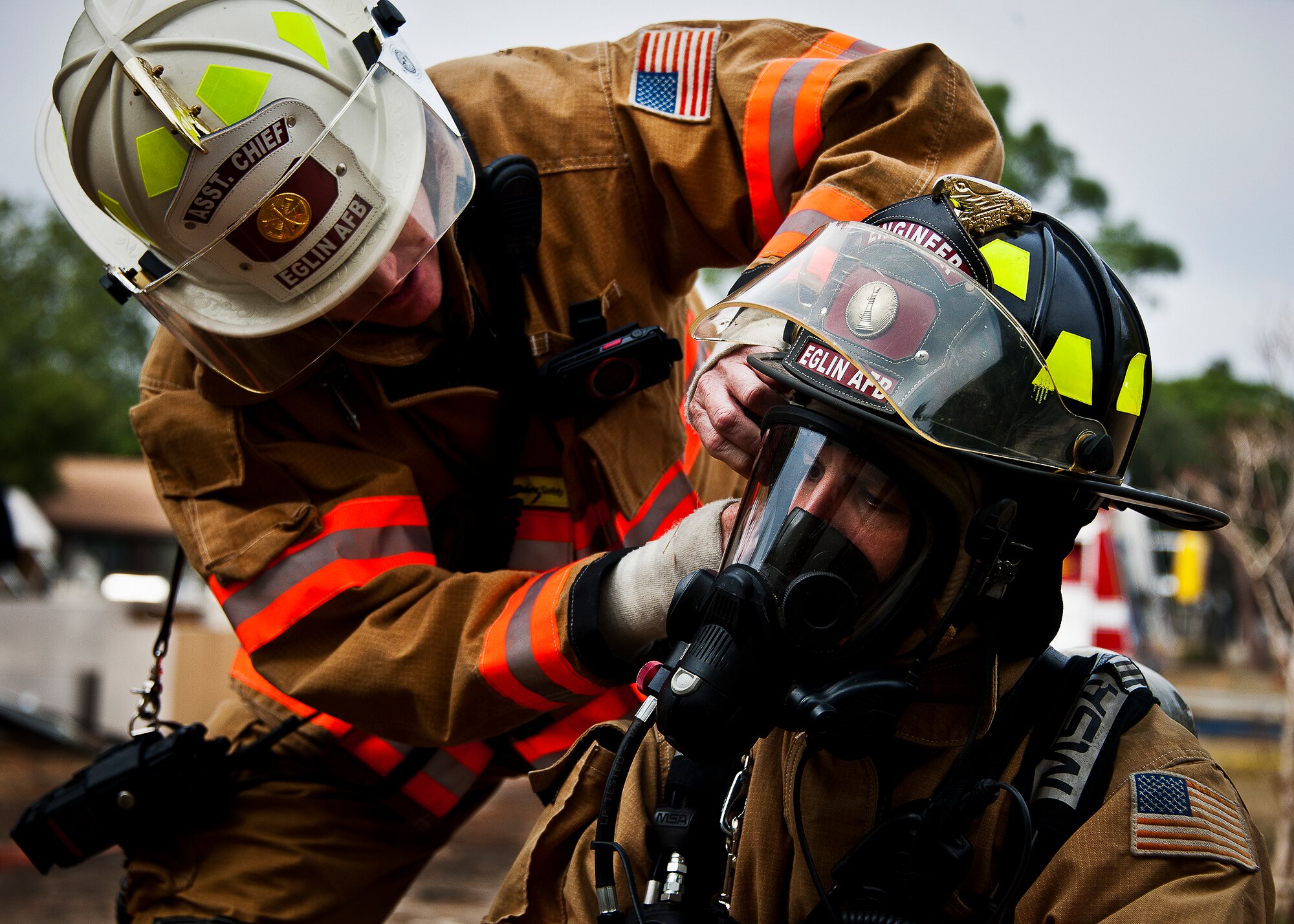 Master Sgt. Luis Ortiz-Acevedo ensures a firefighter's personal protective equipment is secured before entering the building during the structural live-fire training exercise at Eglin Air Force Base, Fla., Dec. 13.  Two-person teams entered a building on fire and demonstrated hose and various firefighting procedures while engaging the controlled blaze.  (U.S. Air Force photo/Samuel King Jr.)