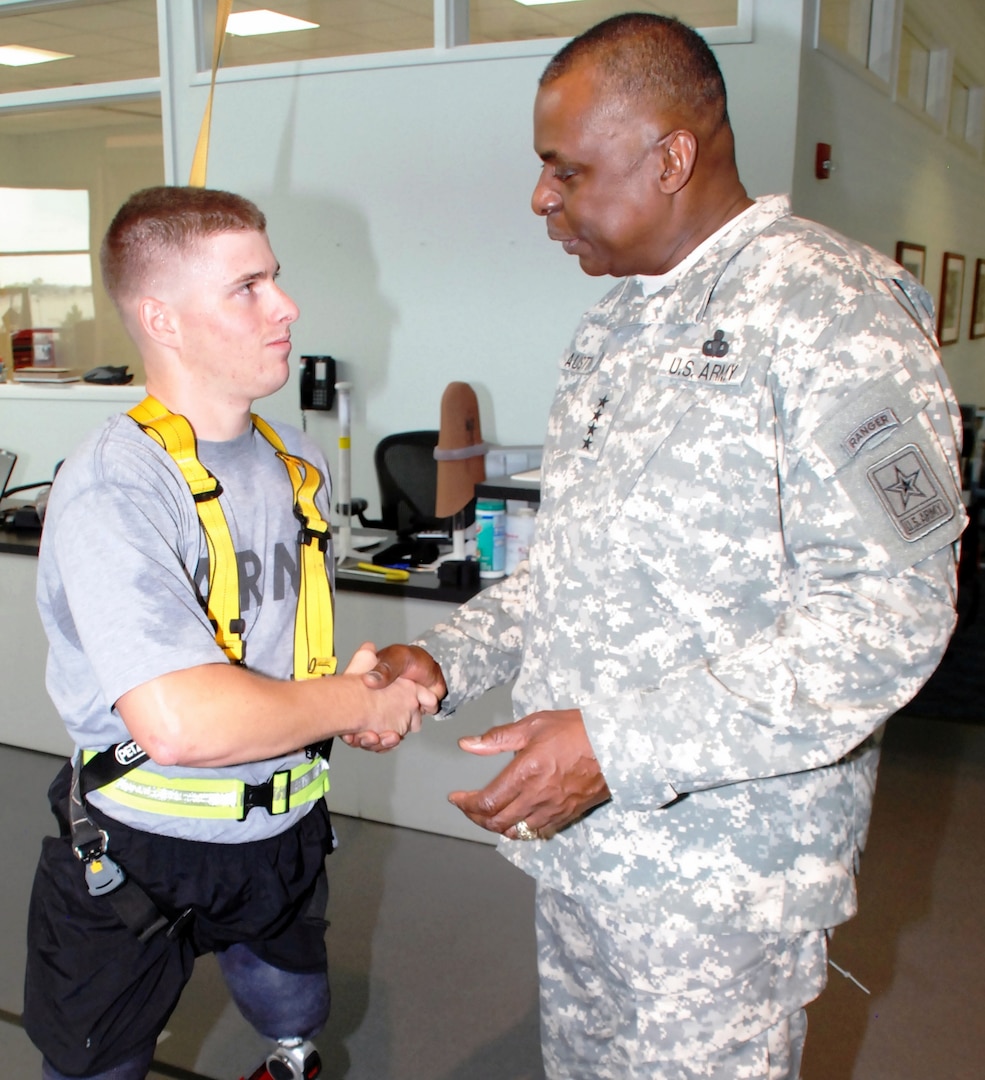 Photo by Robert Shields
Army Vice Chief of Staff Gen. Lloyd J. Austin III coins Army Sgt. Ian Parkinson during his visit to the Center for the Intrepid Dec. 3. Austin visited with wounded warriors after a Purple Heart ceremony held the same day.