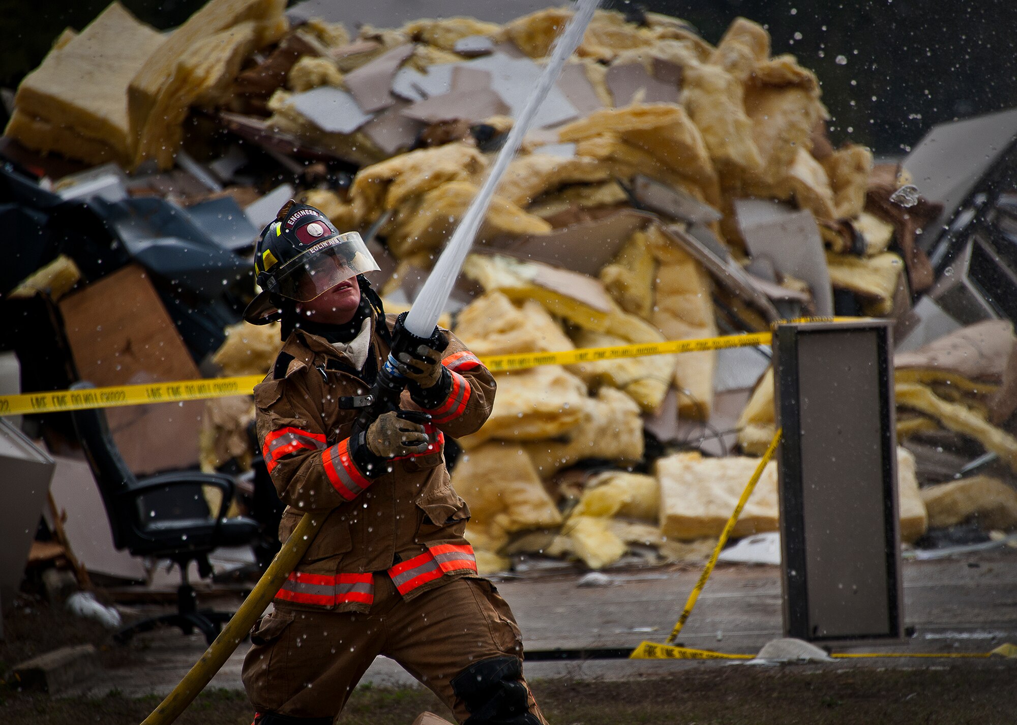 Senior Airman Robert McCallon, a firefighter with the 96th Civil Engineer Squadron, sprays down the roof of a building after a structural live-fire training exercise at Eglin Air Force Base, Fla., Dec. 13.  Two-person teams entered a building on fire and demonstrated hose and various firefighting procedures while engaging the controlled blaze.  (U.S. Air Force photo/Samuel King Jr.)