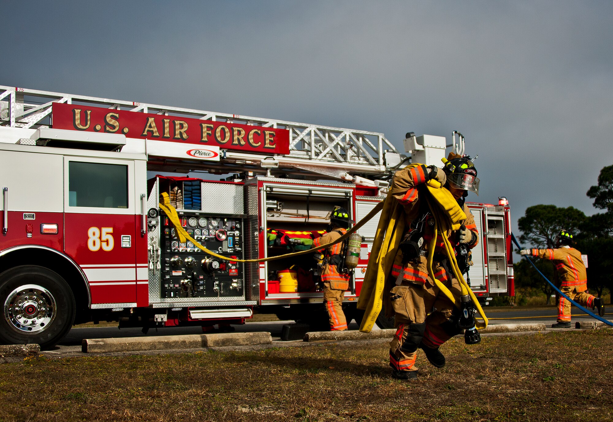 Staff Sgt. Michael Fularz, a firefighter with the 96th Civil Engineer Squadron, pulls hose off of fire truck 85 during the structural live-fire training scenario at Eglin Air Force Base, Fla., Dec. 13.  Two-person teams entered a building on fire and demonstrated hose and various firefighting procedures while engaging the controlled blaze.  (U.S. Air Force photo/Samuel King Jr.)