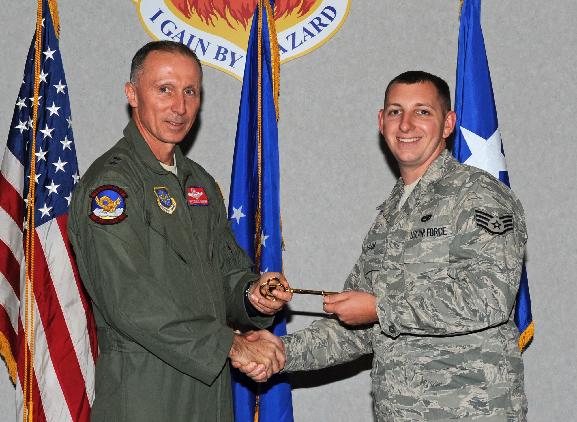 Maj. Gen. William J. Bender, U.S. Air Force Expeditionary Center commander, presents Staff Sgt. Ryan Sloan, 317th Aircraft Maintenance Squadron, with the honorary key to the newest C-130J Dec. 13, 2012, at Dyess Air Force Base, Texas. This is the 24th C-130J of 28 to be delivered to Dyess by 2013, replacing the legacy fleet of C-130Hs. Once the final aircraft is delivered, Dyess will be home to the largest C-130J fleet in the world. (U.S. Air Force photo by Airman 1st Class Peter Thompson/Released)