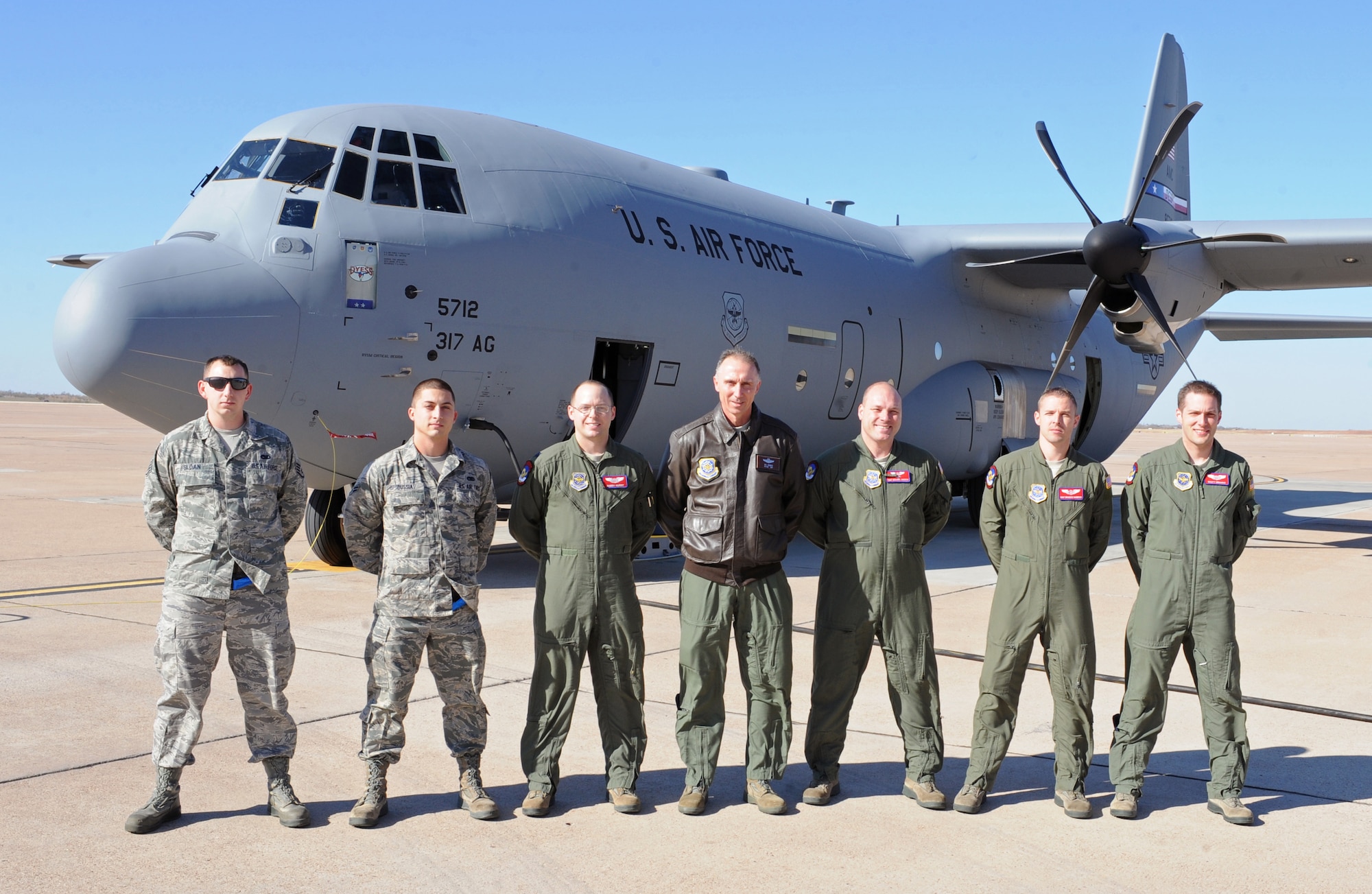 Members of the 317th Airlift Group pose for a group photo with Maj. Gen. William J. Bender, U.S. Air Force Expeditionary Center commander, after delivering the 317th AG’s newest C-130J Dec. 13, 2012, at Dyess Air Force Base, Texas. This is the 24th C-130J of 28 to be delivered to Dyess by 2013, replacing the legacy fleet of C-130Hs. Once the final aircraft is delivered, Dyess will be home to the largest C-130J fleet in the world.  (U.S. Air Force photo by Airman 1st Class Peter Thompson/Released)
