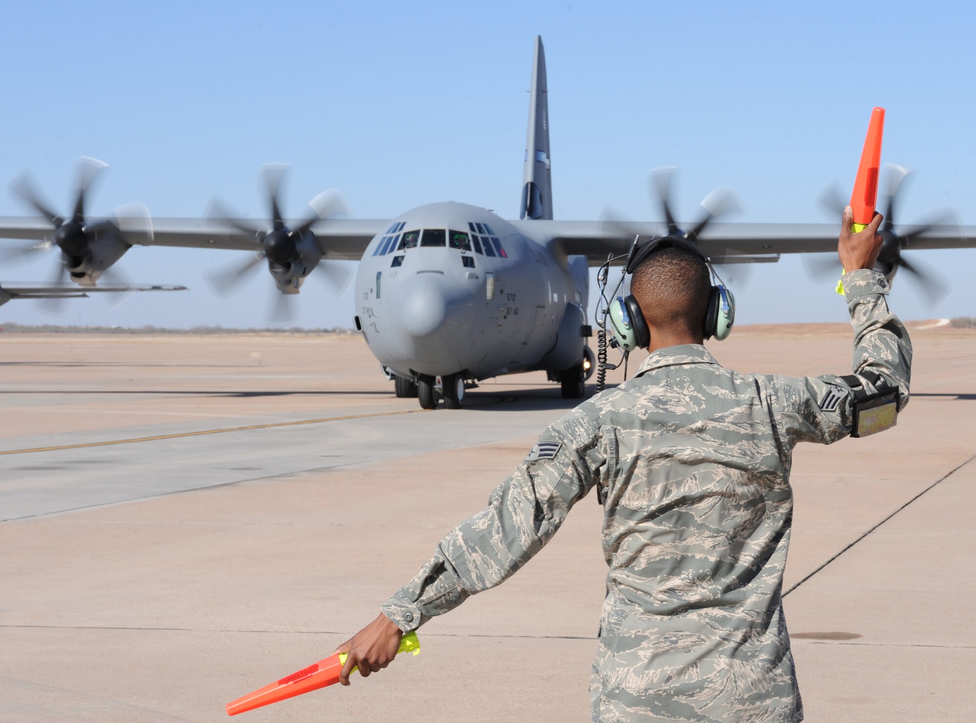 U.S. Air Force Senior Airman Antonio White, 317th Aircraft Maintenance Squadron, marshals in the 317th Airlift Group’s newest C-130J Dec. 13, 2012, at Dyess Air Force Base, Texas. This is the 24th C-130J of 28 to be delivered to Dyess by 2013, replacing the legacy fleet of C-130Hs. Once the final aircraft is delivered, Dyess will be home to the largest C-130J fleet in the world. (U.S. Air Force photo by Airman 1st Class Peter Thompson/Released) 